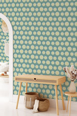 The wallpaper has a vibrant blue background with a repeating pattern of stylized vintage flowers in cream and pale green with circular yellow centers. The flowers are evenly spaced and arranged in rows, creating a retro-inspired design. The overall look adds a cheerful and nostalgic vibe to the room, reminiscent of mid-century decor, giving the space a lively yet traditional wallpaper.