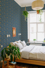 A bedroom with blue wallpaper adorned with small orange pumpkins and yellow crescent moons, giving a whimsical Halloween pumpkin patch vibe, traditional wallpaper.