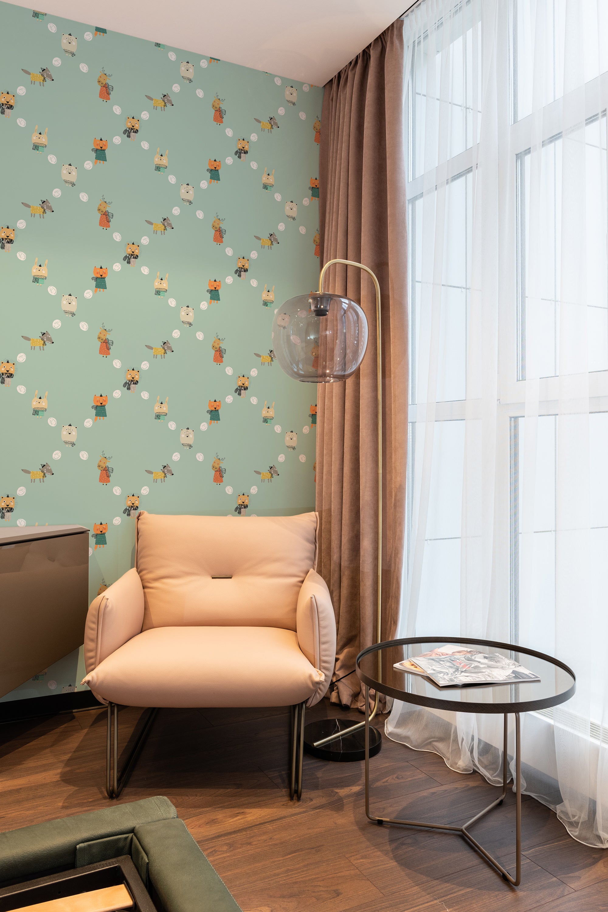 A cozy room corner with light green wallpaper adorned with illustrations of baby cartoon animals, including bears, foxes, and rabbits, complemented by a neutral-toned armchair and sheer curtains, traditional wallpaper.