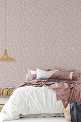 A bedroom with a wall covered in pinkish delicate floral wallpaper, complementing the soft bedding colors, providing a serene and elegant ambiance, traditional wallpaper.