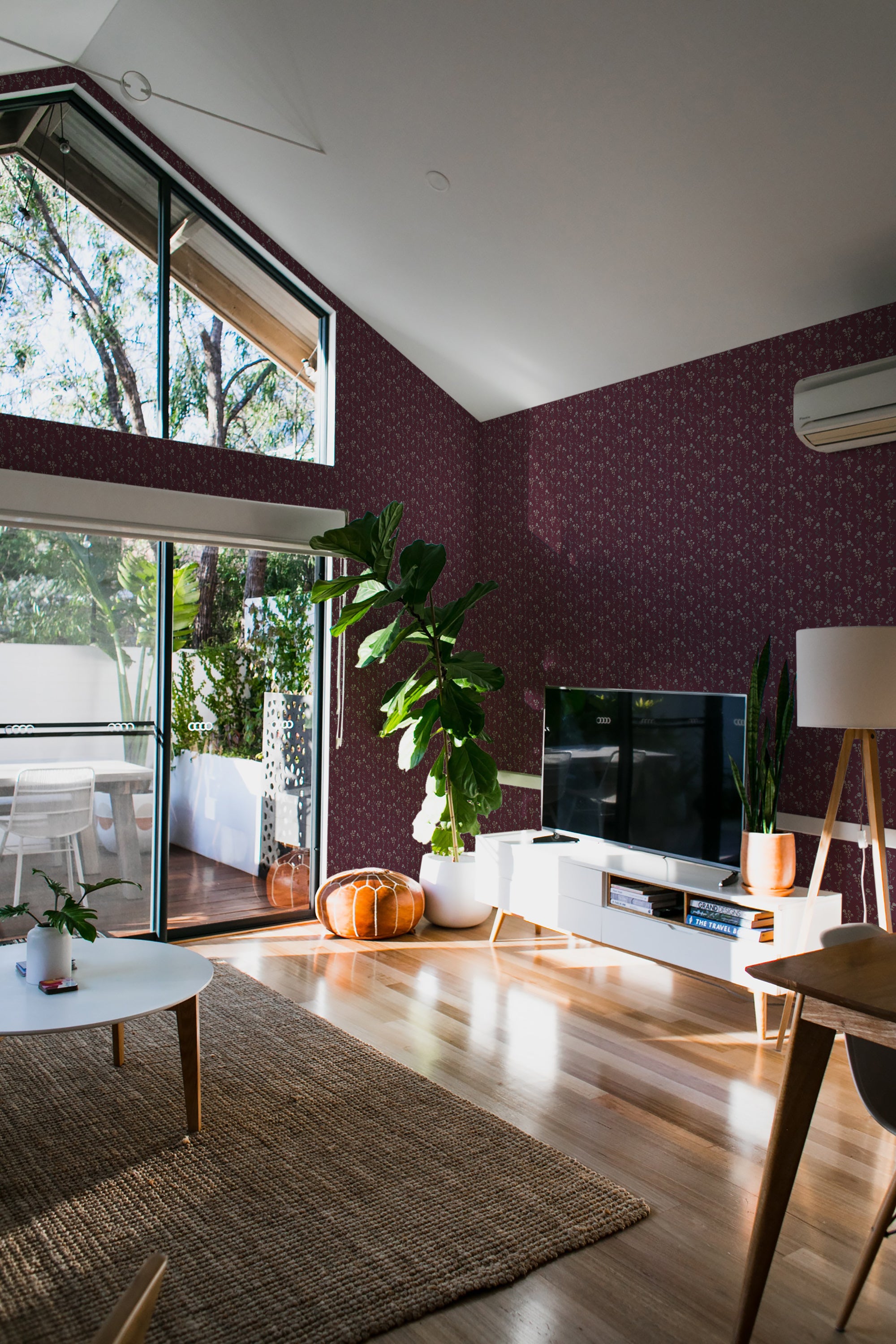 A cozy room with walls adorned in traditional wallpaper with dark burgundy flowers.