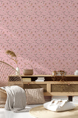 Pink wallpaper adorned with ballerina silhouettes in various dance poses, adding a whimsical touch to the room's decor in a traditional wallpaper style.