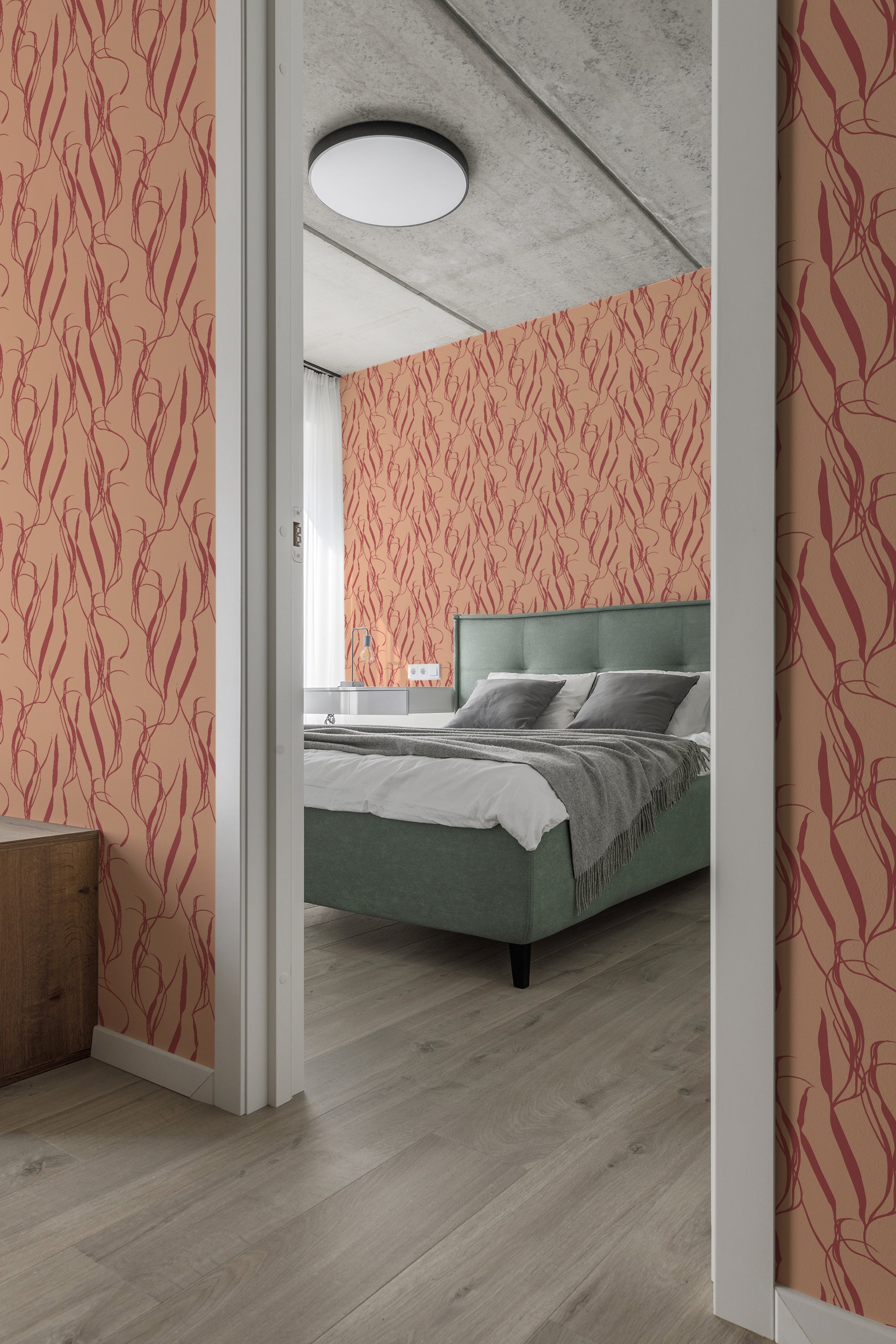 A bedroom with walls covered in coral-colored wallpaper with a stylized aesthetic plant pattern, complementing a green bed and wooden furnishings, traditional wallpaper.
