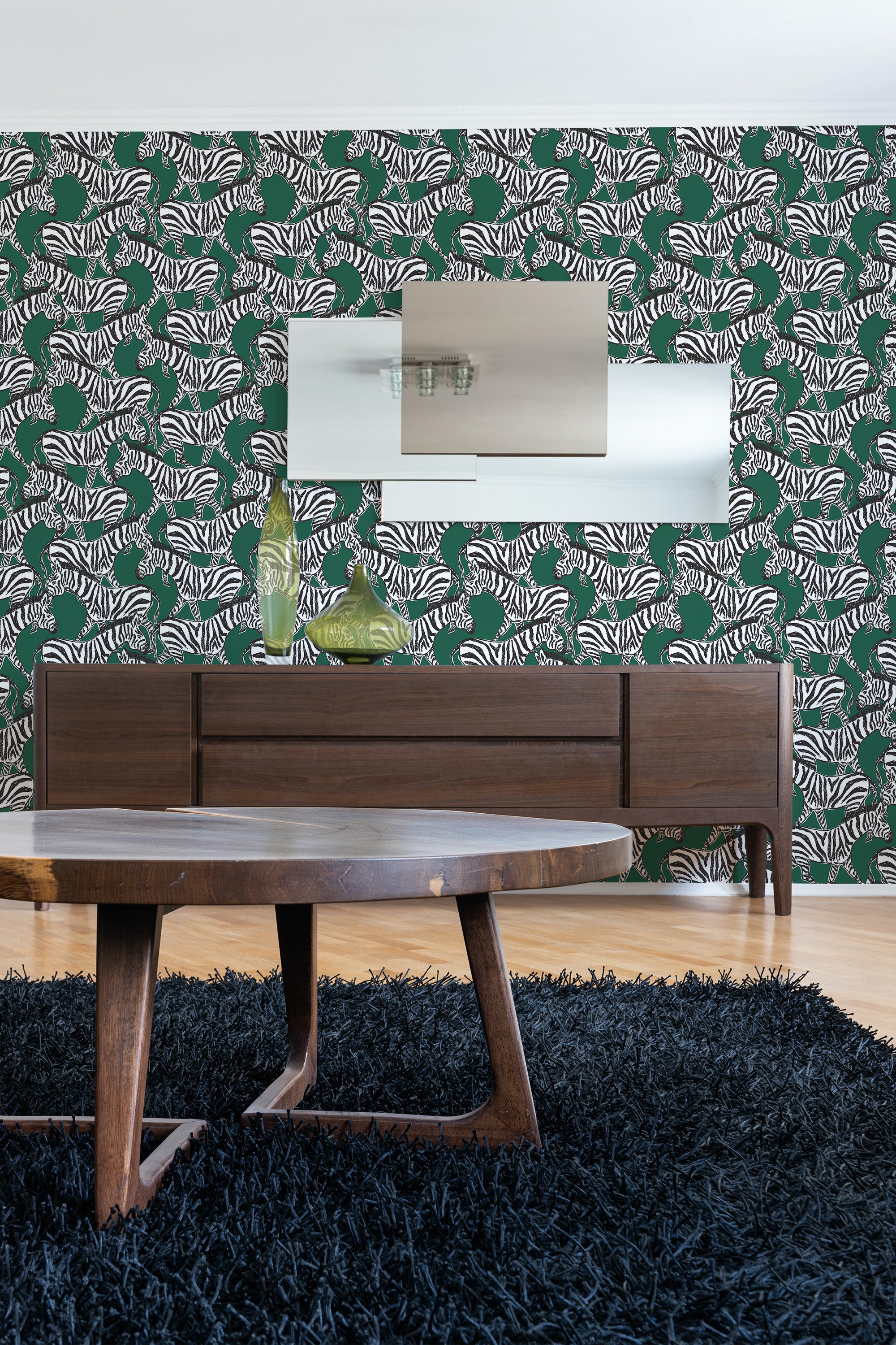 A room with a wall covered in forest green wallpaper patterned with white zebra stripes, above a wooden sideboard and a shaggy blue rug, giving a bold contrast and a traditional wallpaper look.