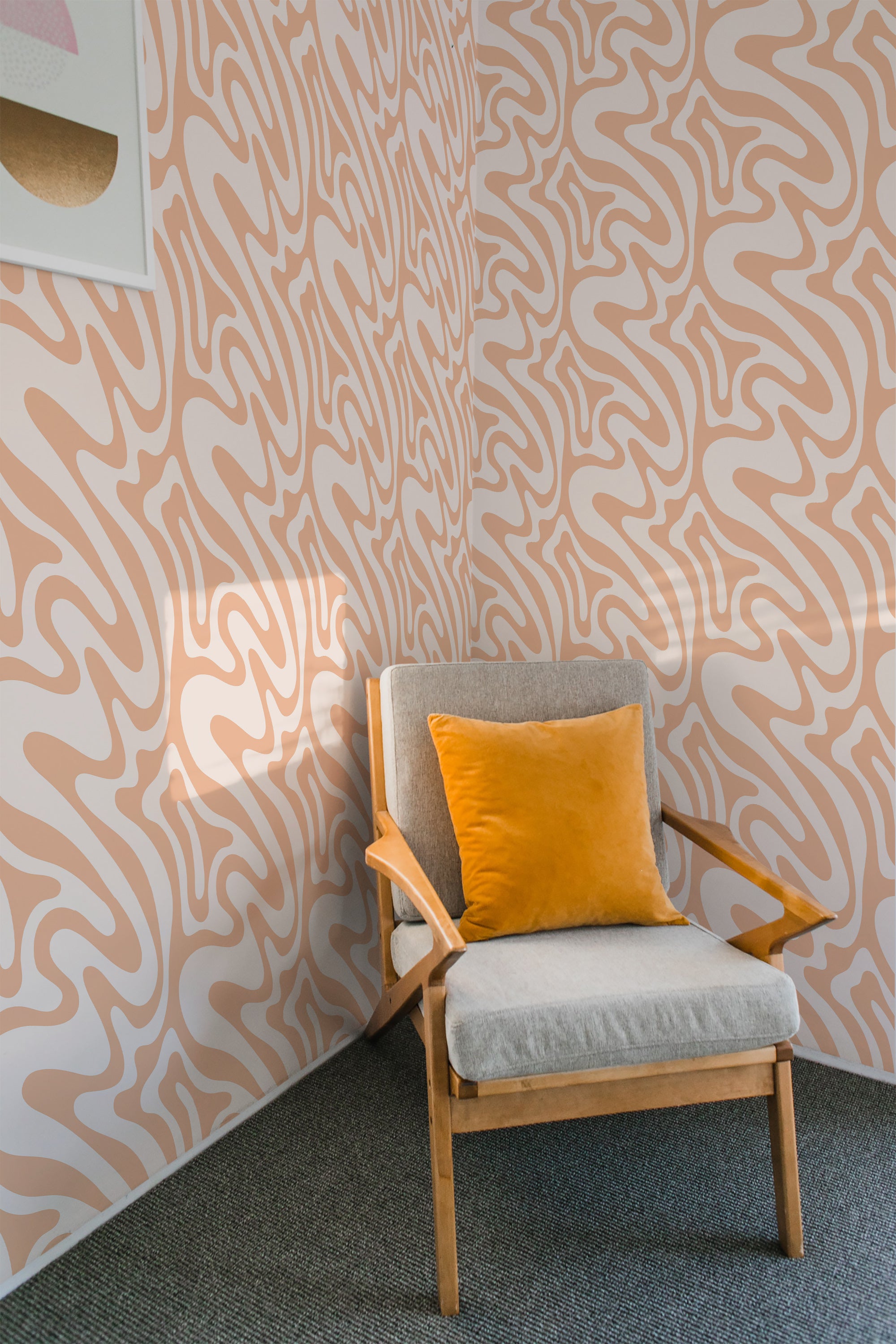 A peach-colored wallpaper with funky, abstract wave patterns on a wall behind a chair with a yellow cushion, invoking a retro feel in a modern setting as traditional wallpaper.