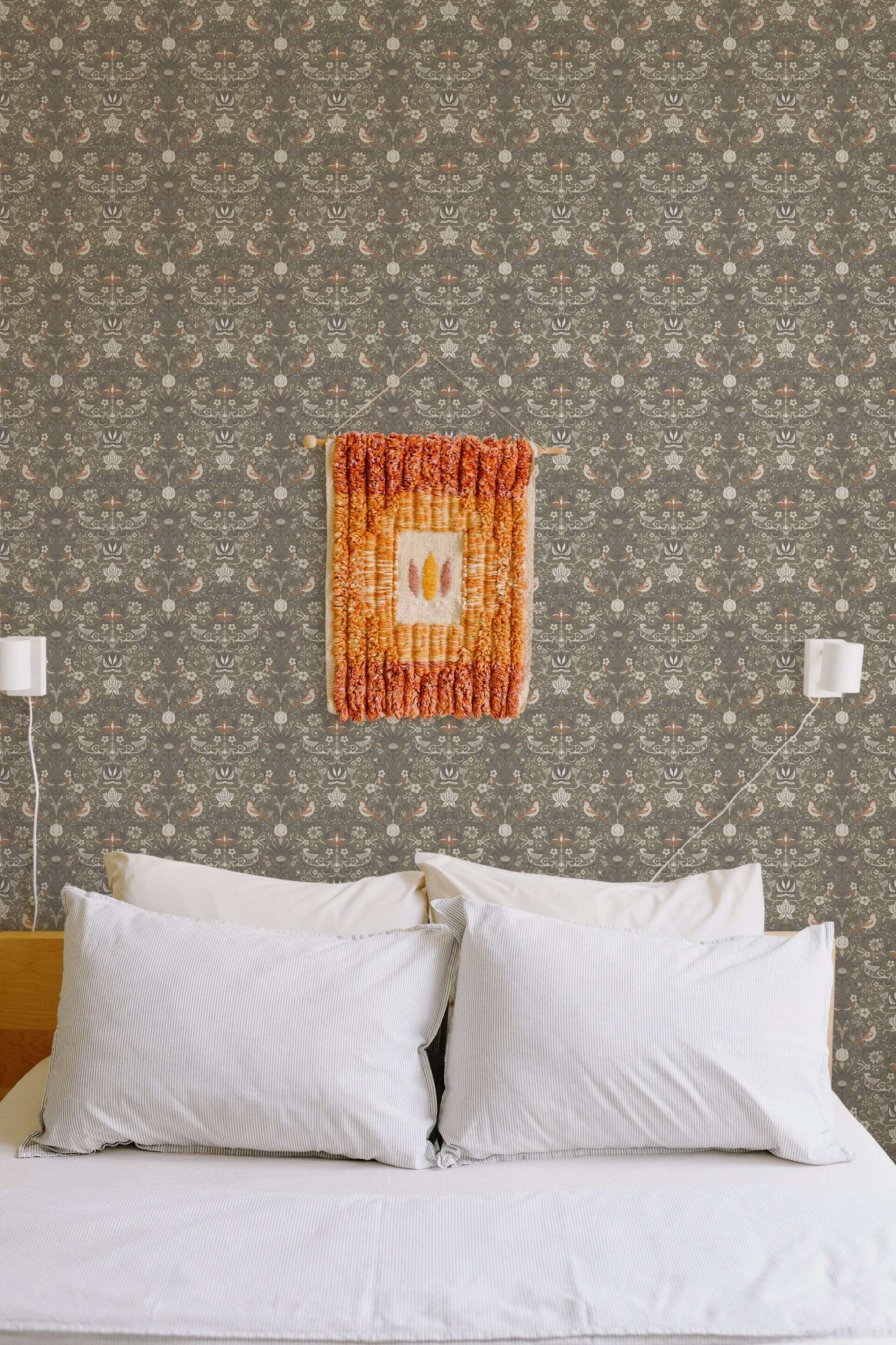 Self-adhesive Vintage springtime wallpaper with a floral pattern on a bedroom wall, above a bed with white pillows.