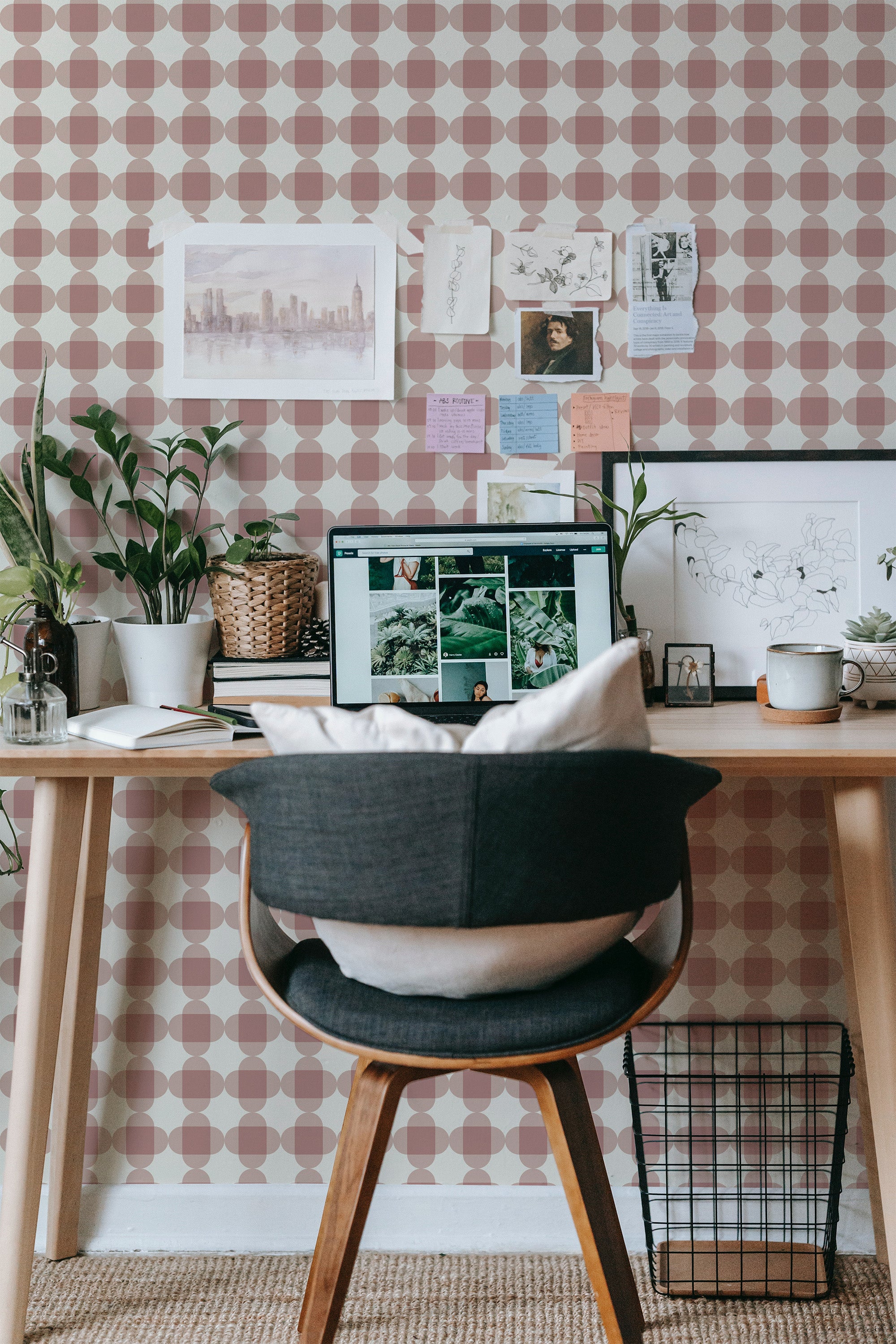 Self-adhesive wallpaper with a plaid geometric pattern in shades of pink and white, complementing a cozy workspace with a wooden desk and chair.
