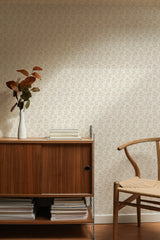 Self-adhesive wallpaper with a repeating pattern of cute stylized bunnies on a neutral background in a furnished room with a wooden sideboard and chair.
