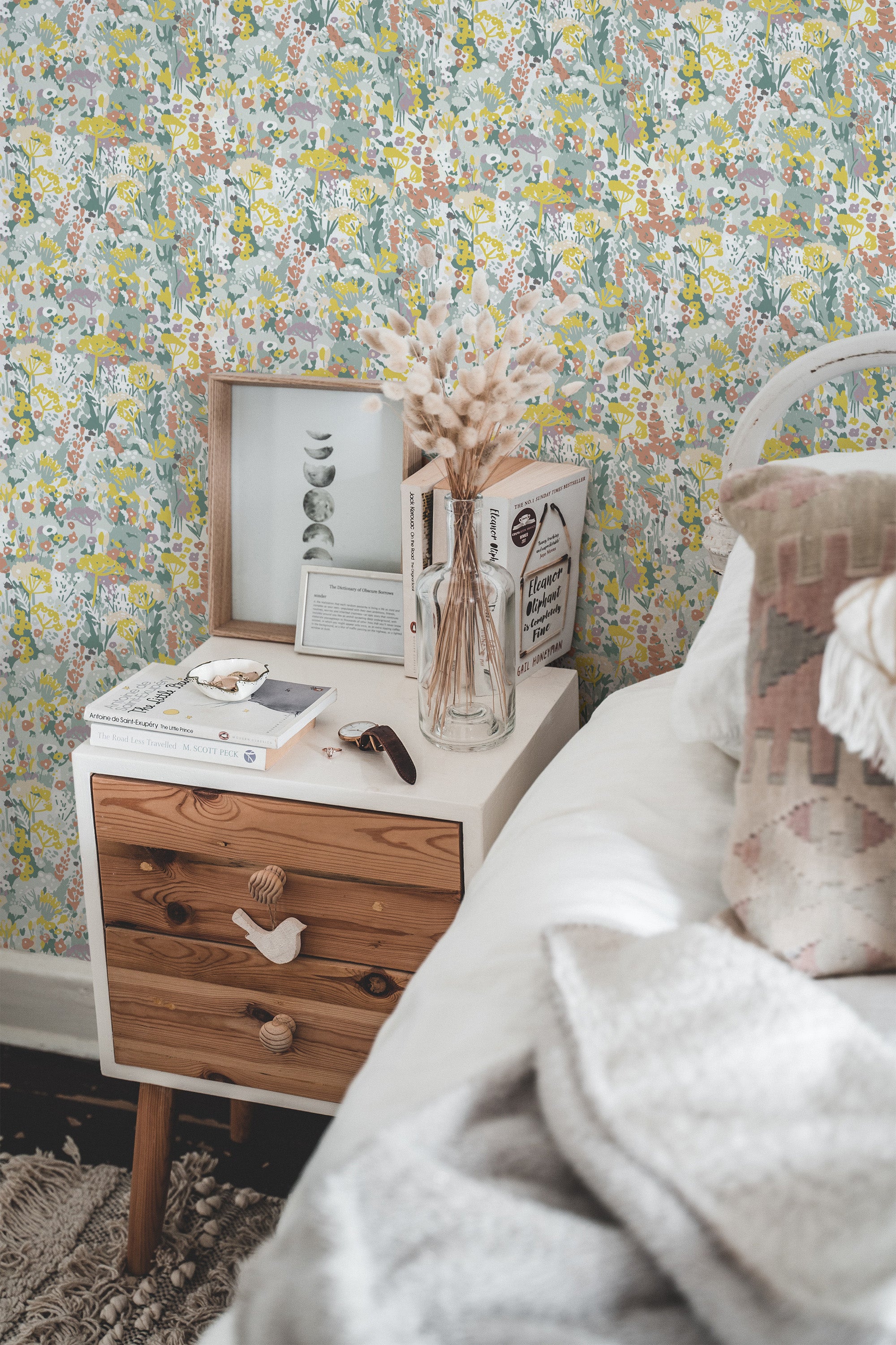 Self-adhesive wallpaper with colorful abstract summer meadow design in a cozy room setting with bedside table and decor.