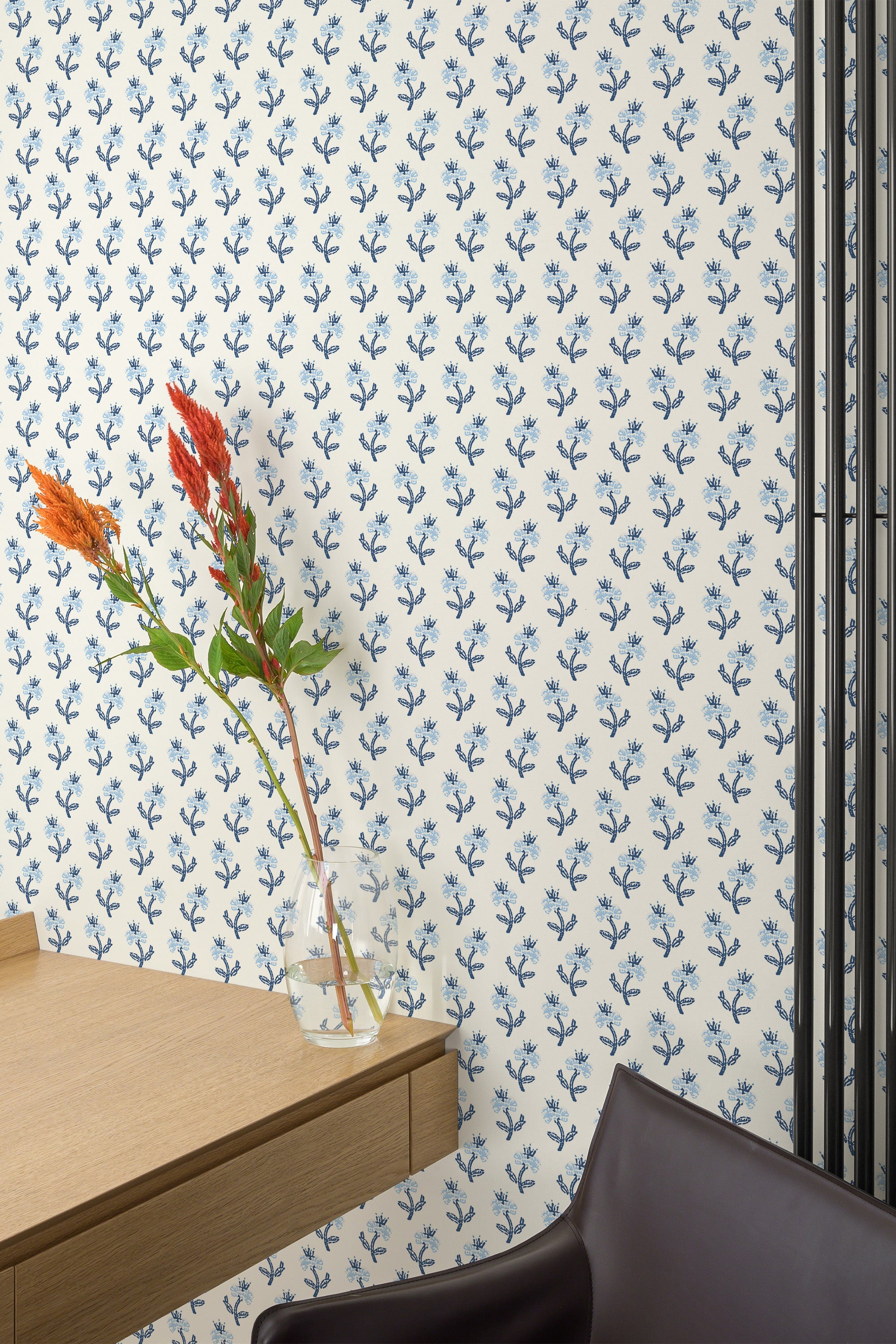 Self-adhesive aesthetic floral pattern wallpaper with blue leaves and occasional red flowers adding a pop of color, affixed to a room's wall with modern furniture.