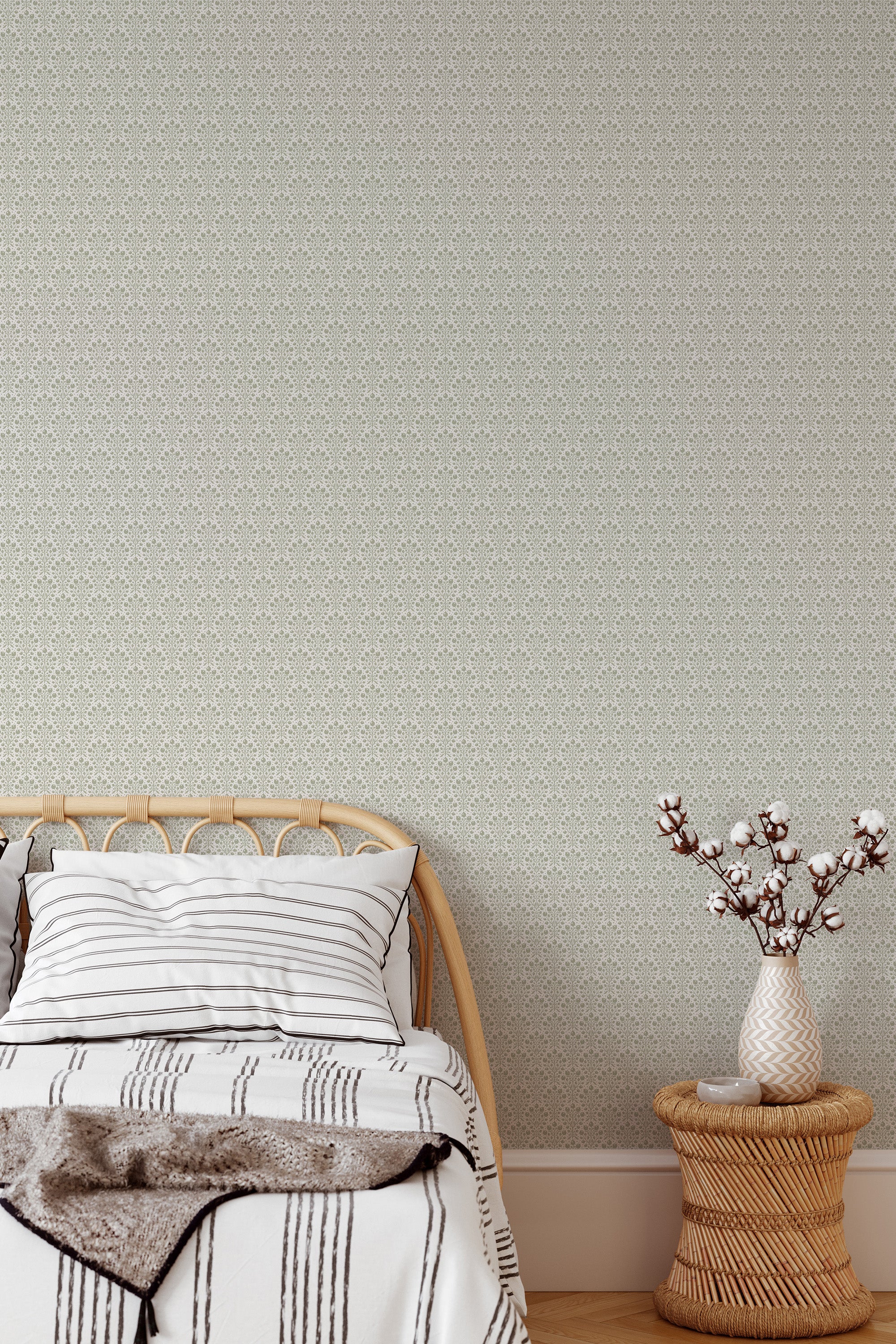 Self-adhesive wallpaper with a delicate berry pattern on a neutral background in a bedroom with a bed and a vase of cotton branches on a stool.