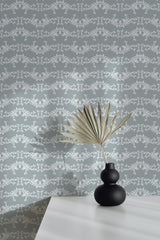 Self-adhesive Elegant damask wallpaper with intricate white and gray patterns on a room wall, complemented by a decorative vase and plant on a table.