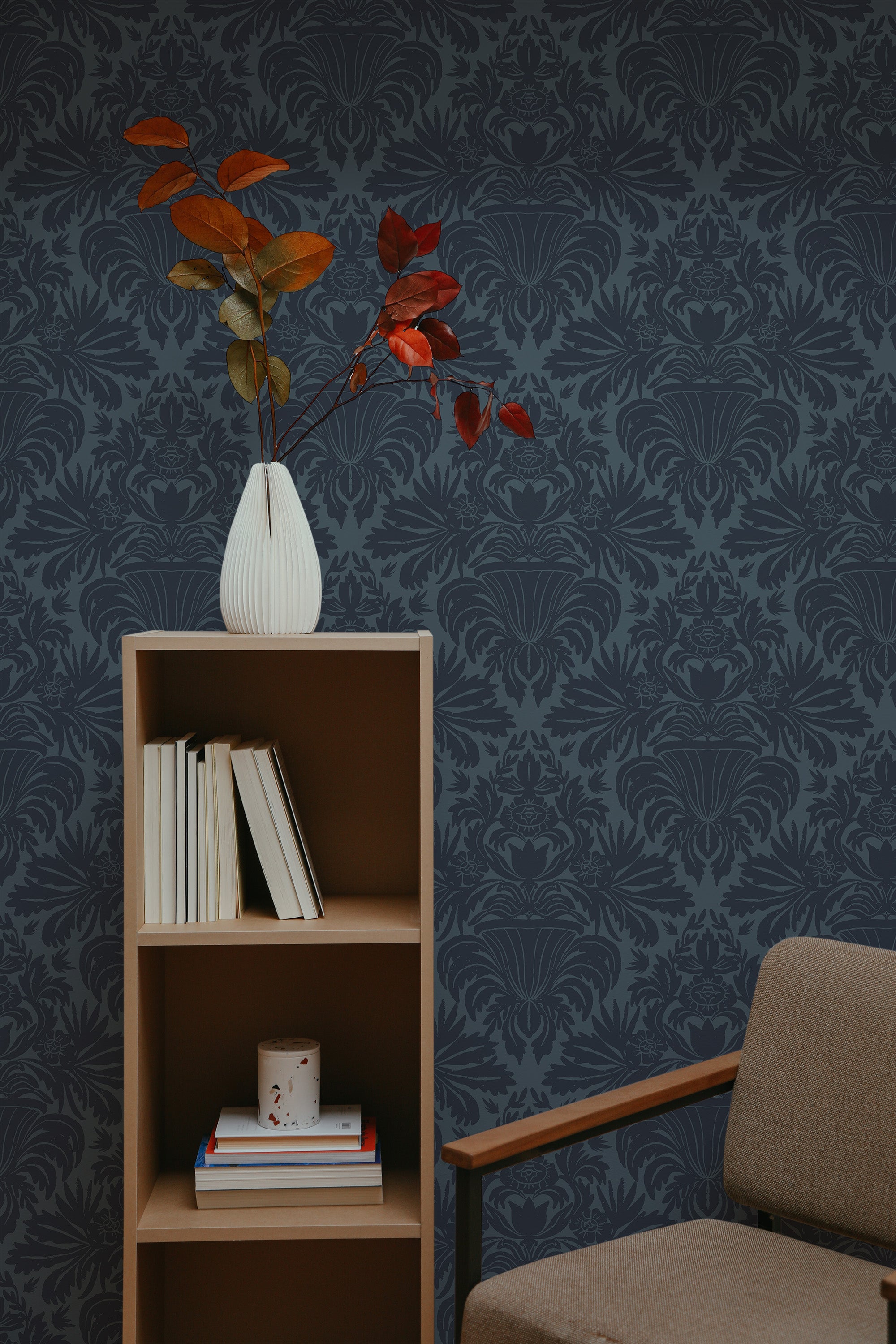Self-adhesive Classic Dark Damask wallpaper with intricate floral patterns on a room wall, complemented by a wooden bookshelf and a vase with red leaves.