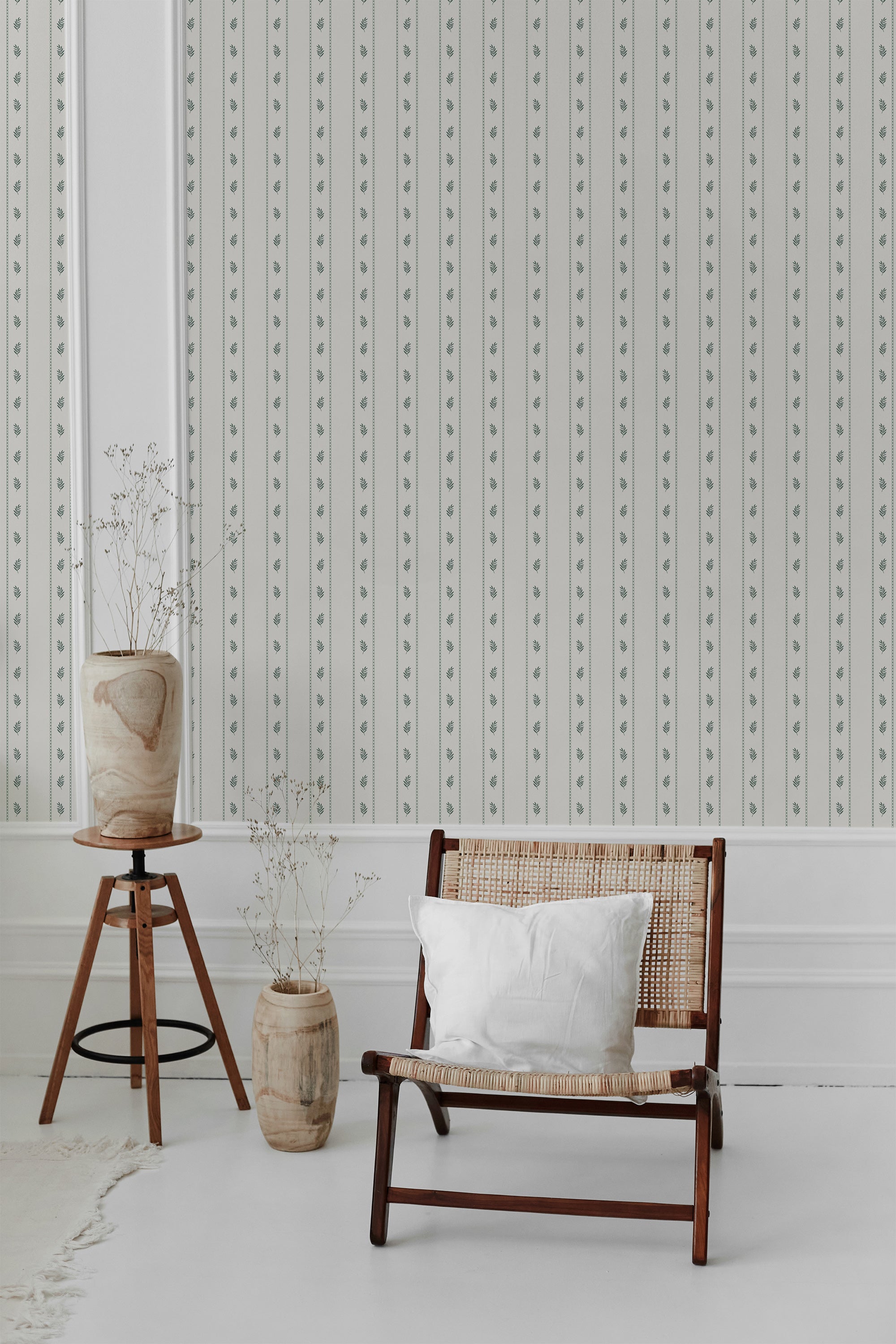 A room with wallpaper bearing a pattern of subtle olive branch lines over a neutral background, creating an elegant and traditional wallpaper.