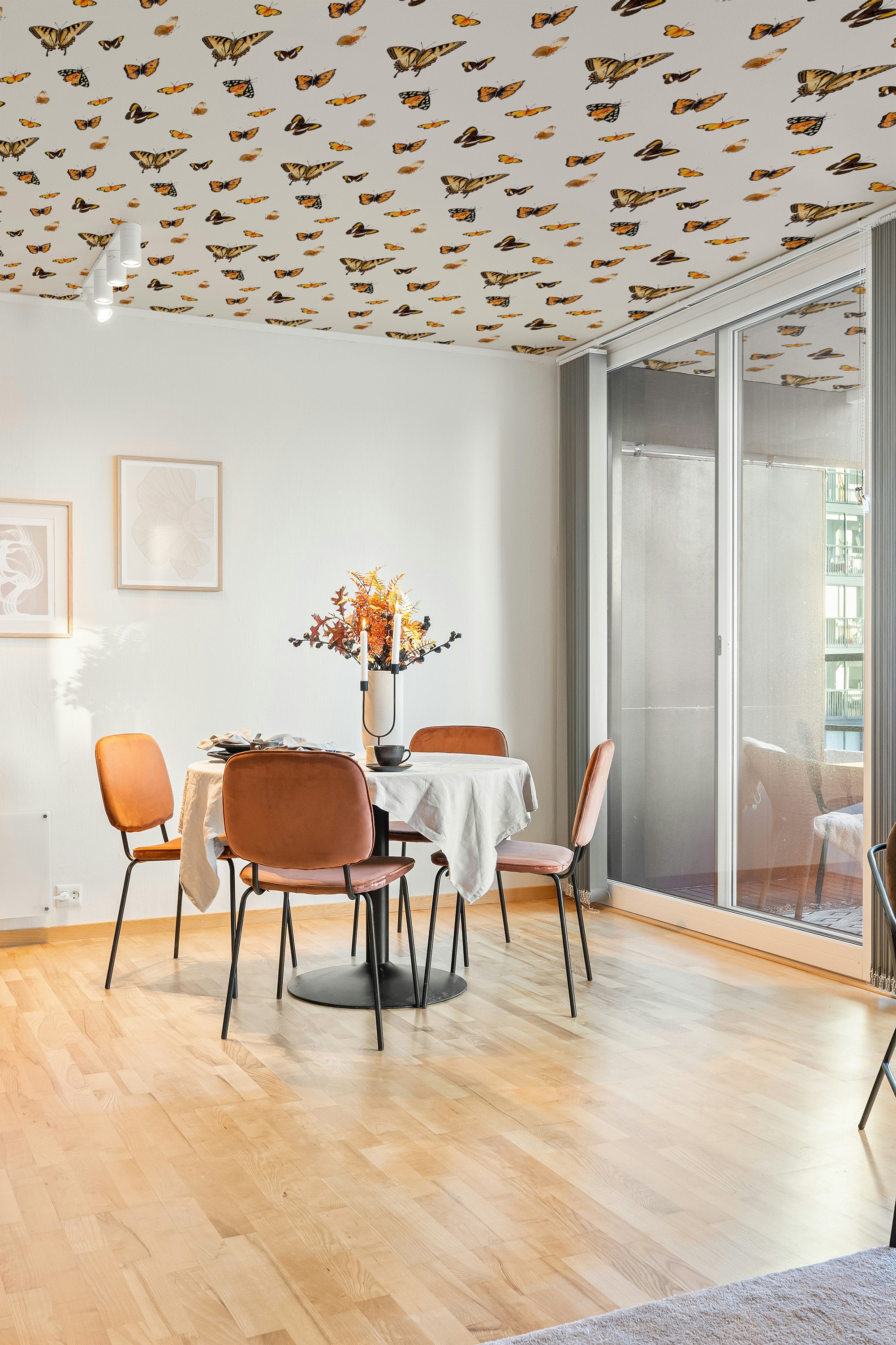 Modern dining room with butterfly-patterned wallpaper and wooden flooring.