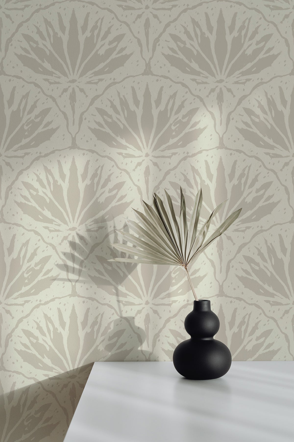 Stylized Lily Bloom pre-pasted wallpaper on an interior wall with repeating lily silhouettes in warm gray on beige.