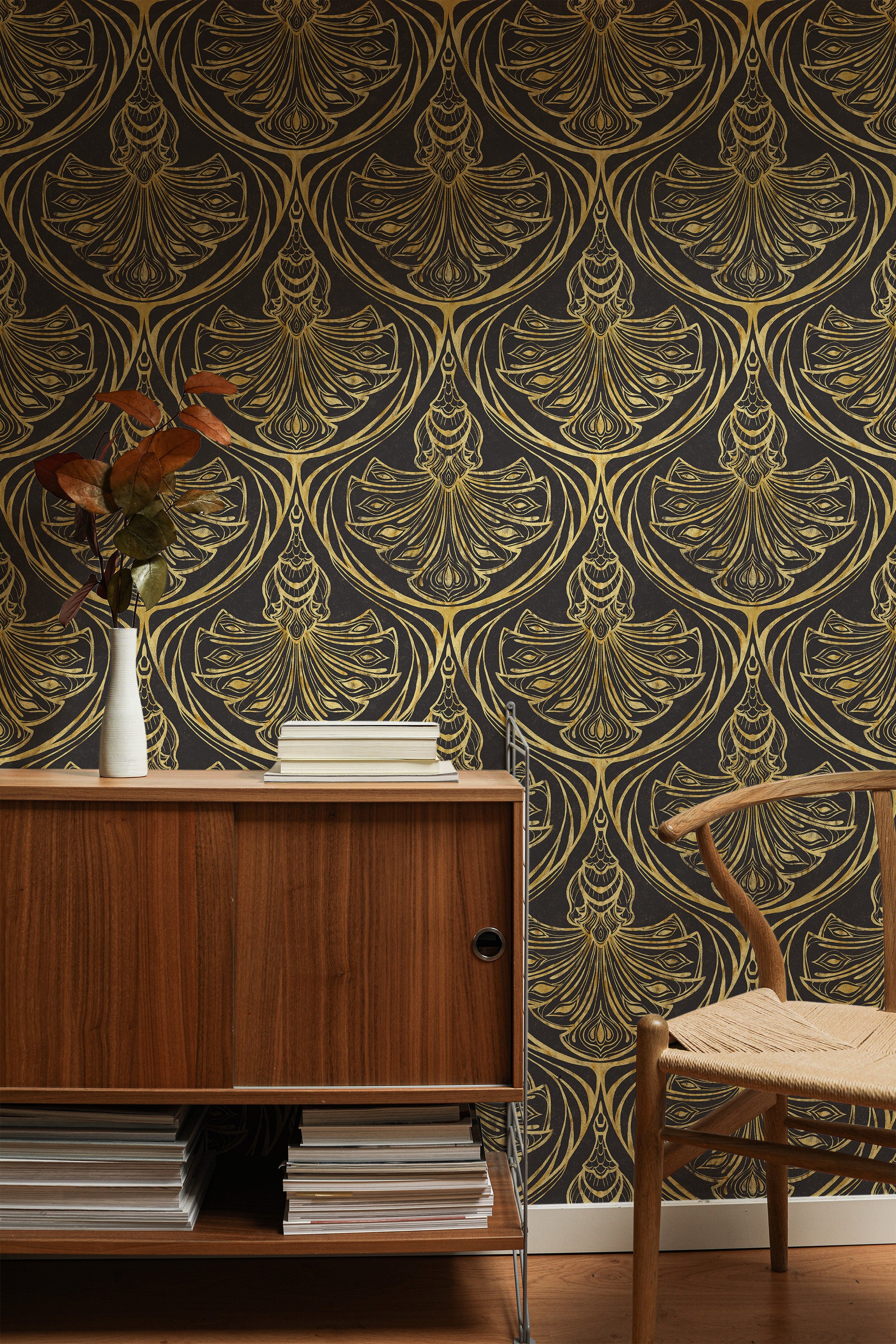 Peacock Damask self-adhesive wallpaper on an interior wall with stylized peacock fan motifs in tan on charcoal.