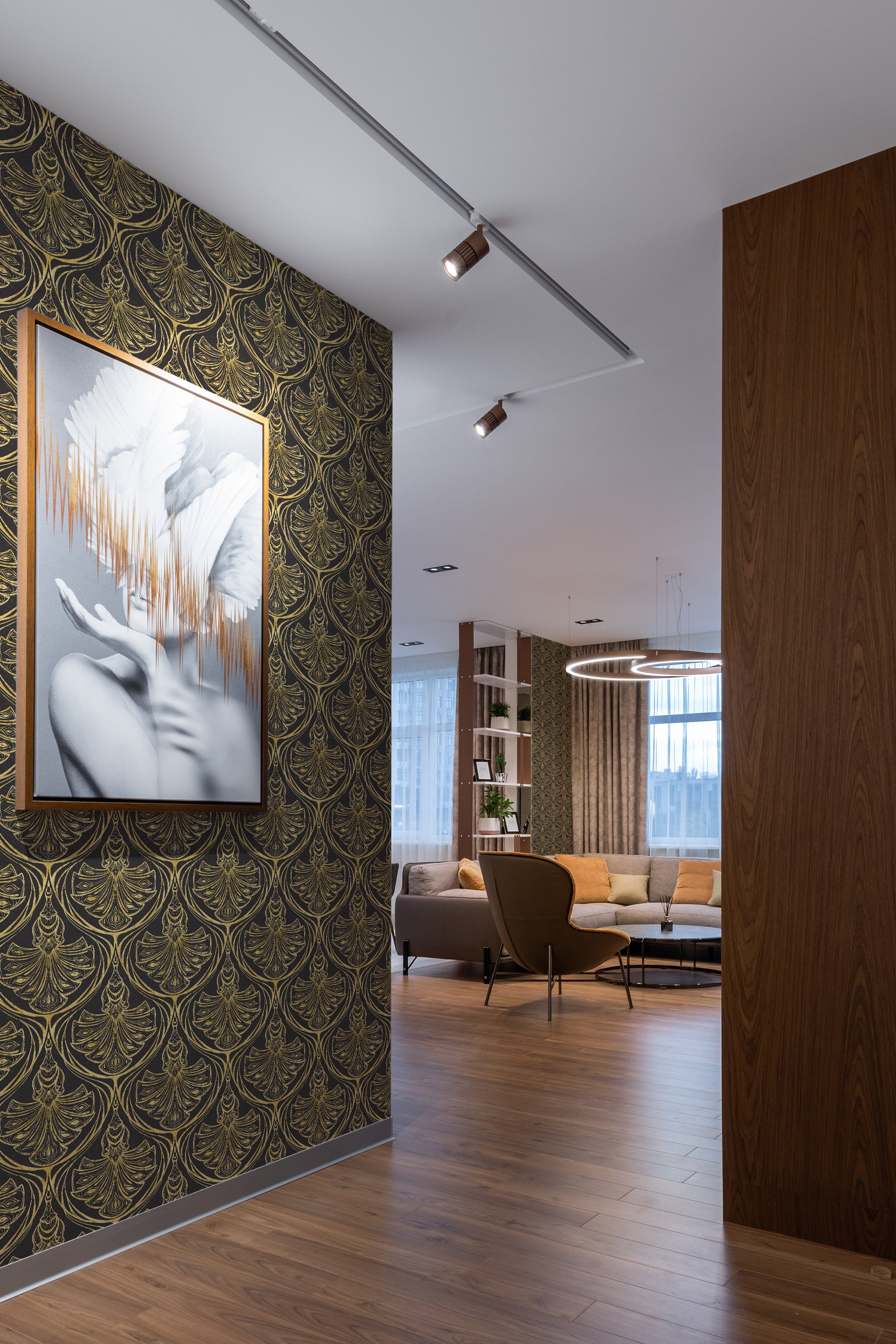Peacock Damask peel and stick wallpaper on a living room accent wall, showing a black ground with an ochre peacock-feather damask repeat.