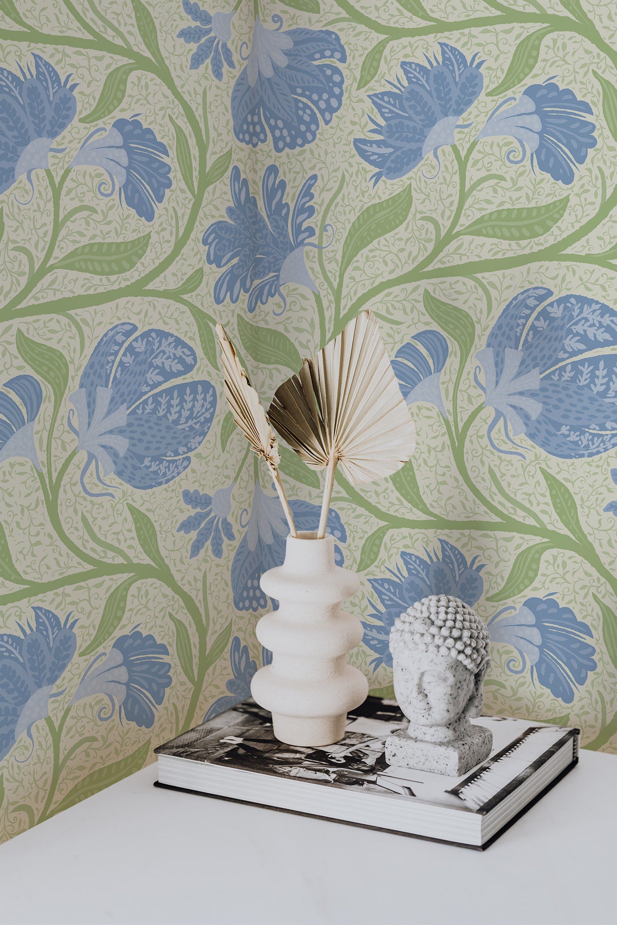 Flowing Floral Vines pre-pasted wallpaper on an interior wall, featuring blue florals and green vines on a pale gray background.