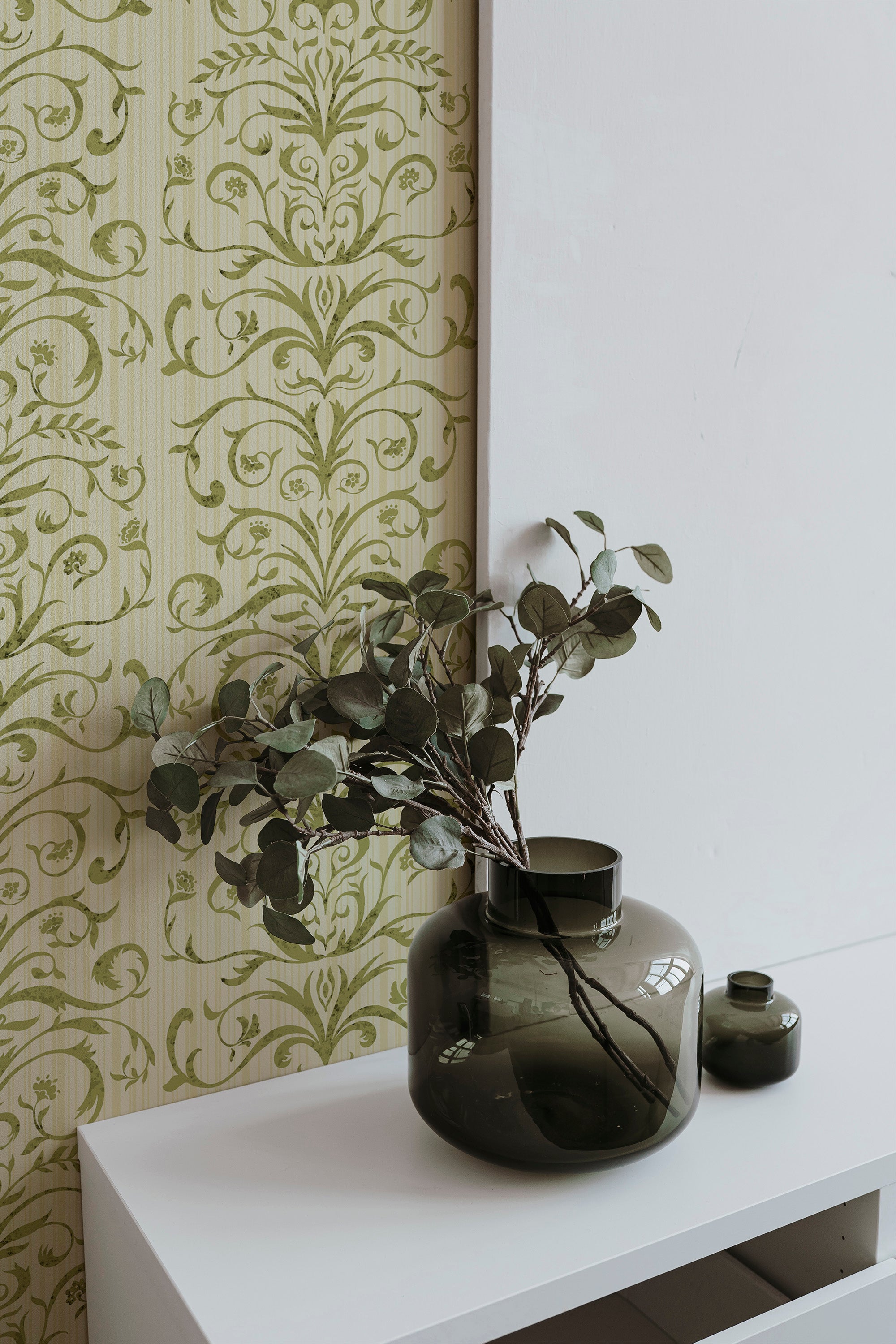 Ornate Vine Damask pre-pasted wallpaper on an interior wall, olive green damask vines over a pale striped ground.
