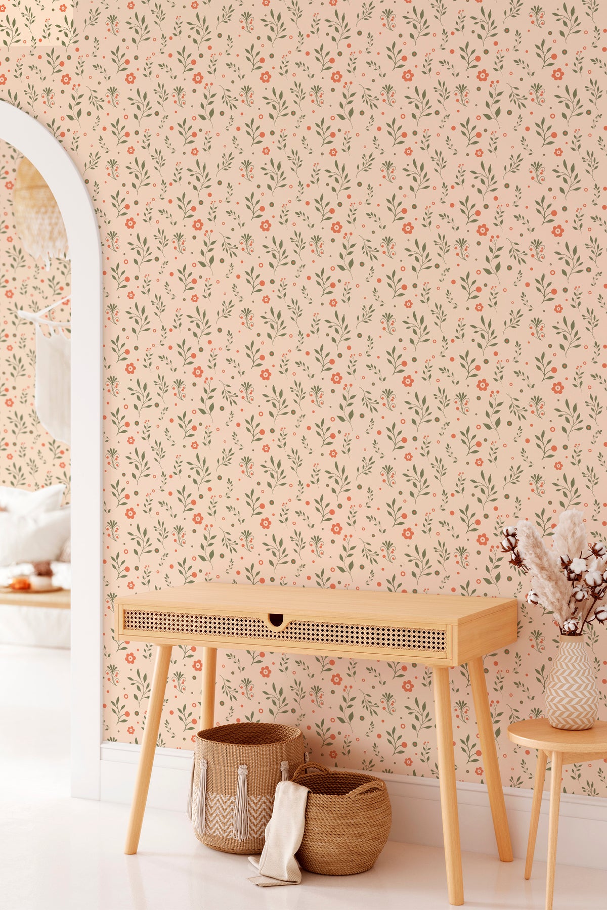 Playful Floral Sprigs grasscloth wallpaper on an interior wall, featuring green sprigs and coral flowers on a beige background.