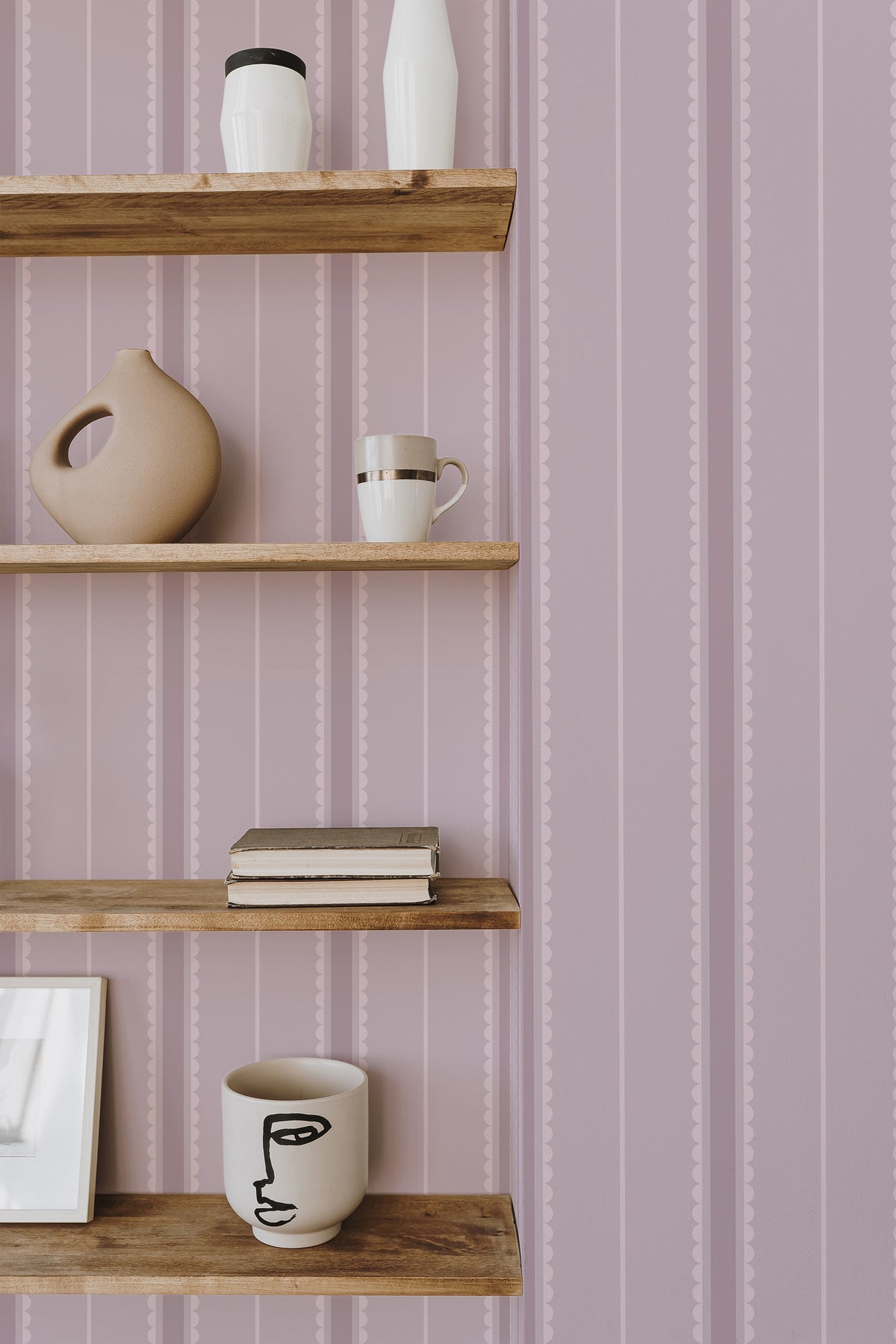 Delicate Scalloped Stripes self-adhesive wallpaper on an interior wall with pink vertical scalloped stripes.