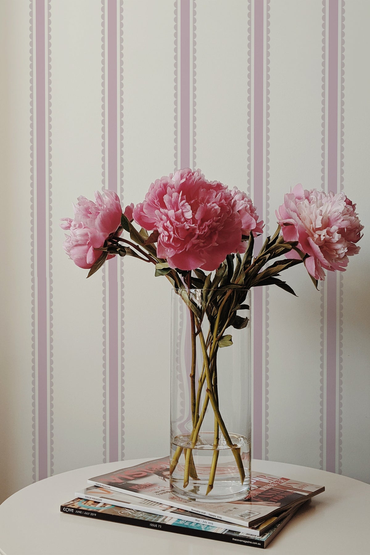 Pastel Scallop Stripe self-adhesive wallpaper on an interior wall, featuring blush scalloped vertical stripes.