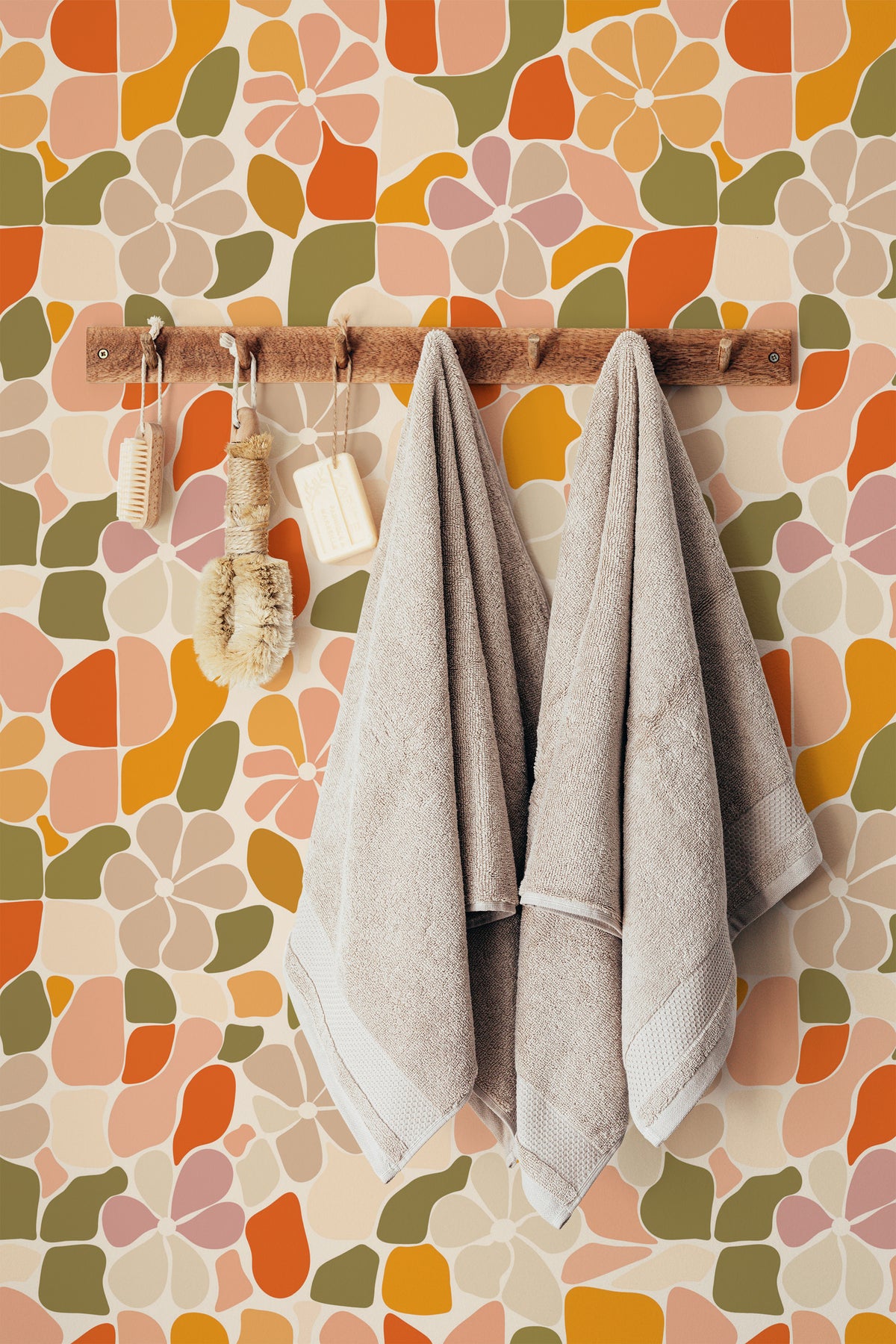 Mosaic Flora grasscloth wallpaper in a bathroom, with large retro floral shapes in pink, olive, and orange.