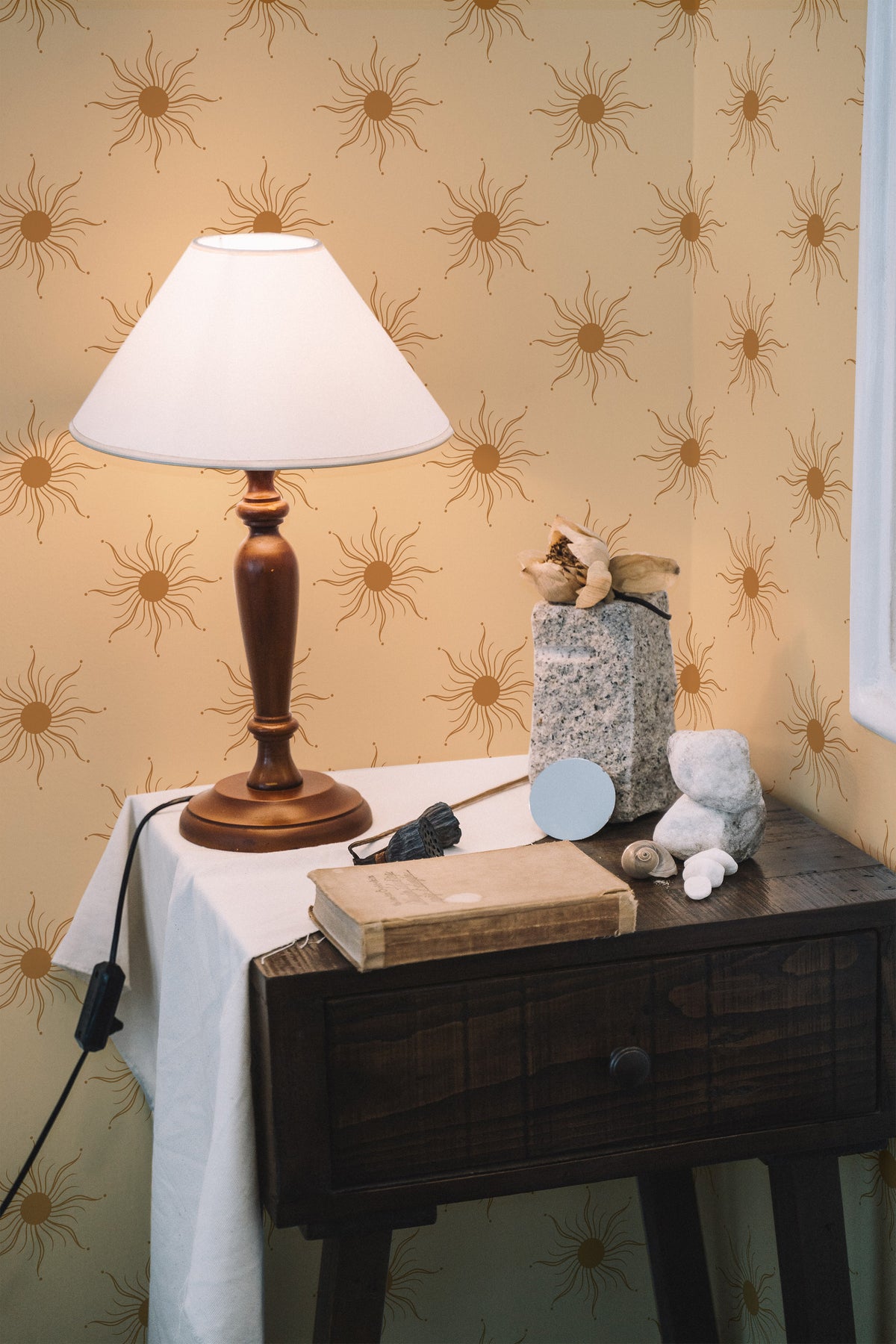 Radiant Sun Motifs peel and stick wallpaper on a bedroom wall, tan sunburst motifs on a warm beige ground.