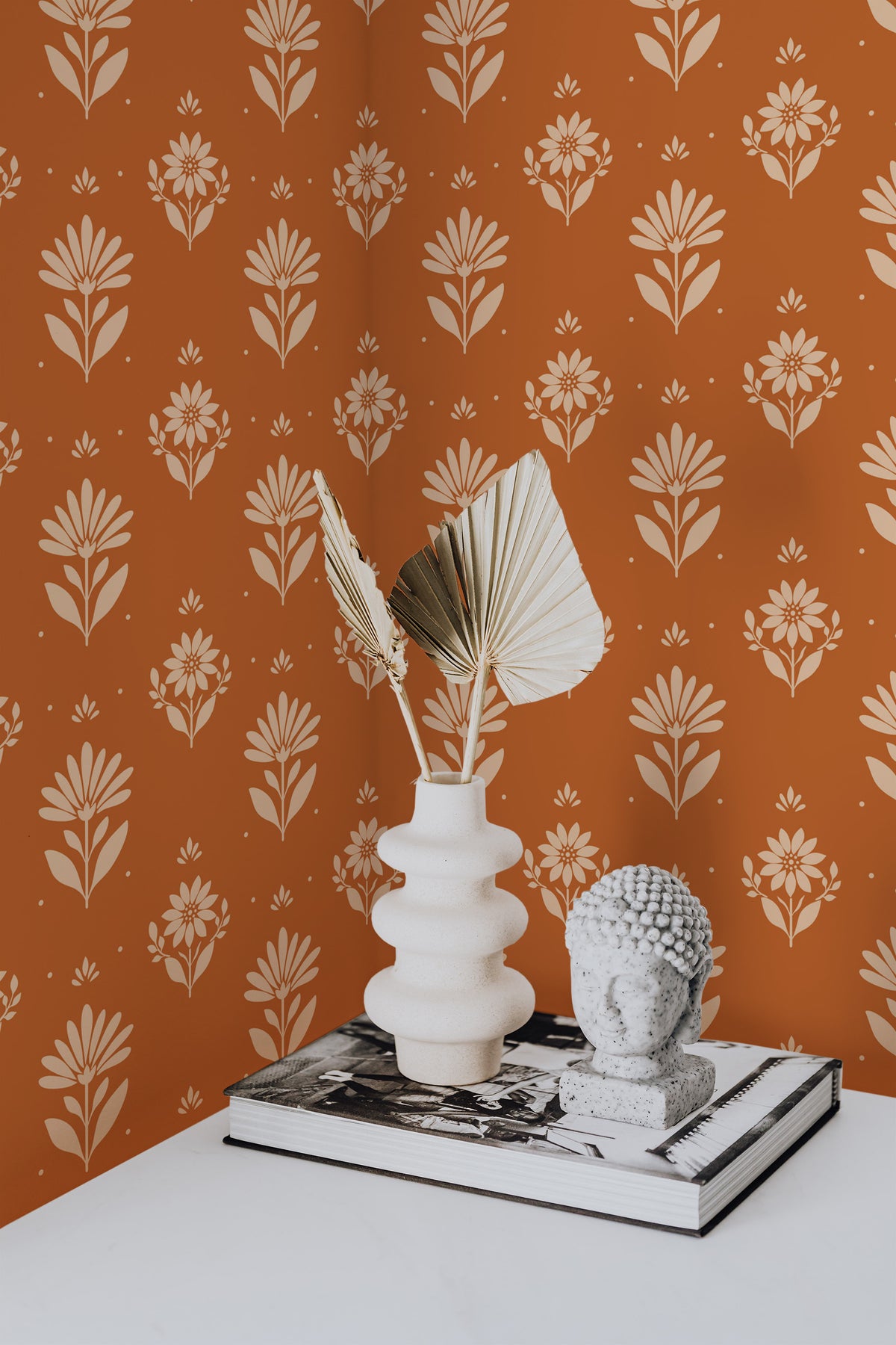 Bold Floral Sprigs grasscloth wallpaper on an interior wall with beige floral sprigs on a rust background.