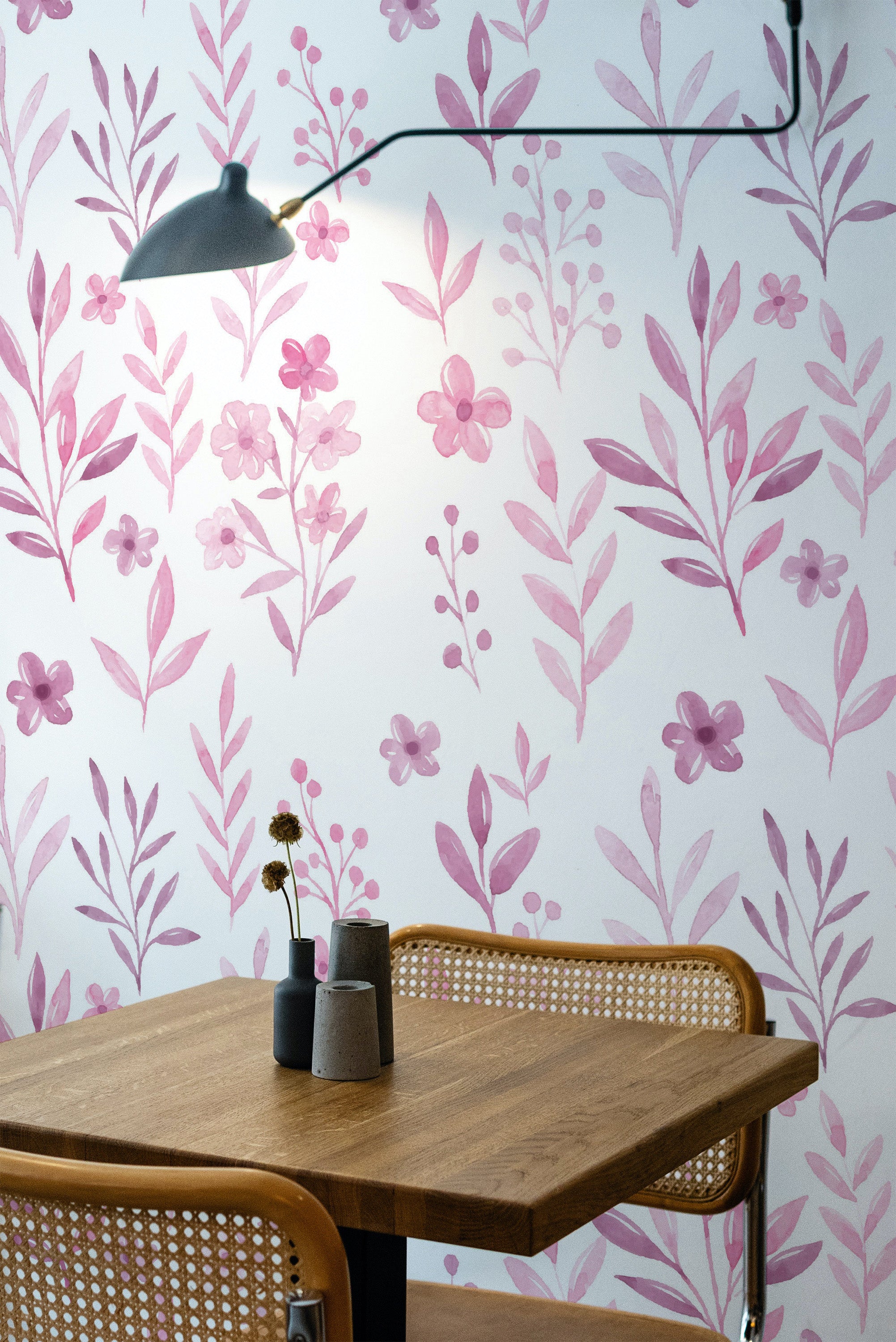 Self-adhesive wallpaper with a pink watercolor floral pattern made up of softly painted flowers, leaves, and stems, balanced on a light background.