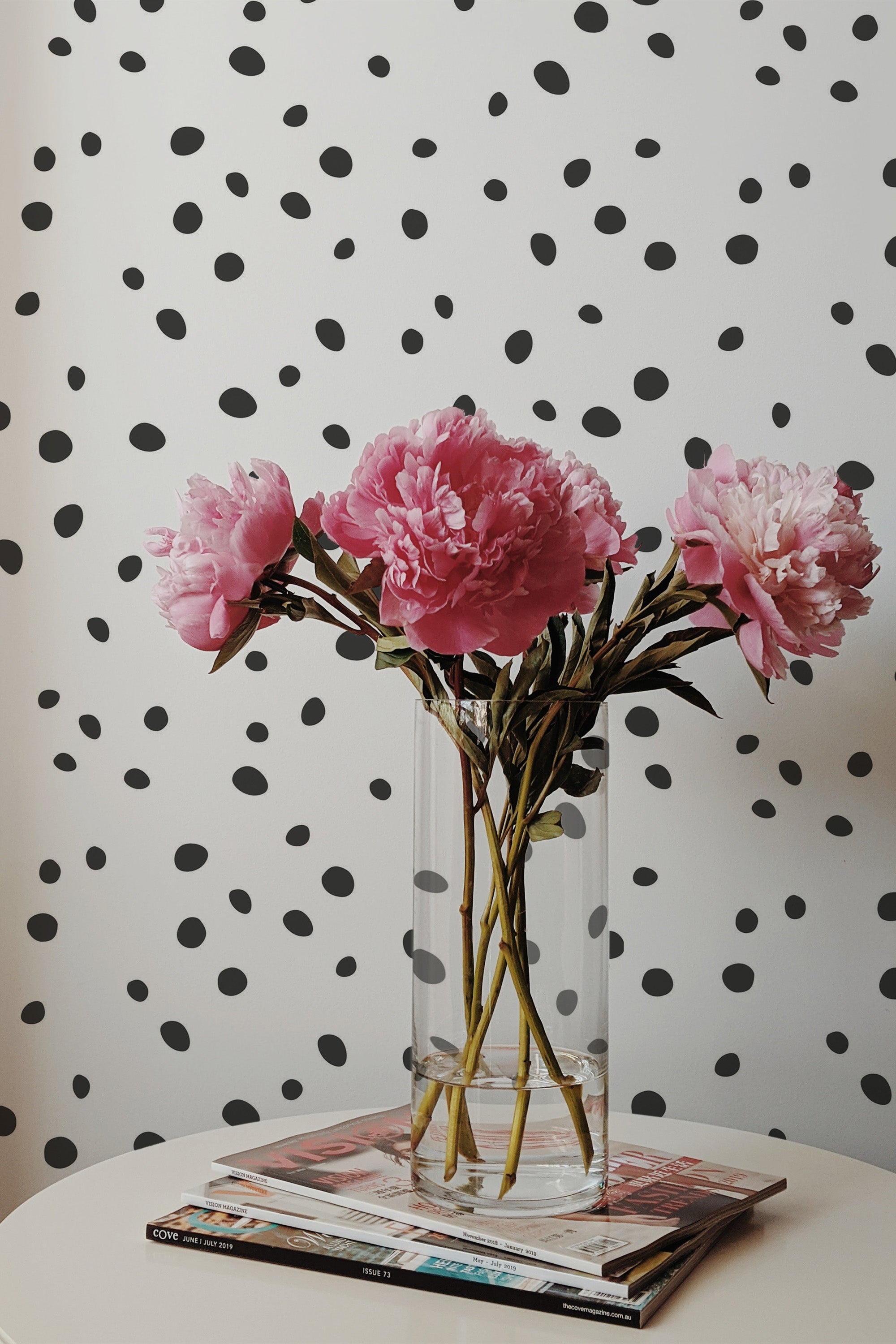 Self-adhesive wallpaper with a simple spotted design of irregular black dots scattered randomly across a clean white background.