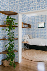 An image showing a room with blue and white mosaic tile pattern on the wallpaper. The design consists of intricate geometric patterns arranged symmetrically on all walls. Traditional wallpaper.