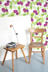 Self-adhesive wallpaper with a vibrant cherry pattern in shades of pink and purple, accented by green leaves against a light background.