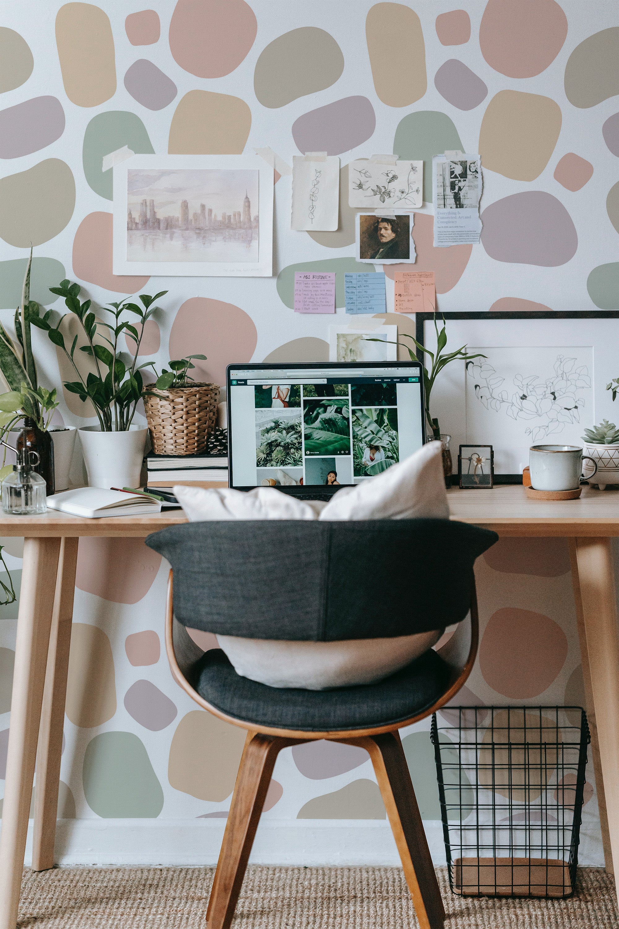 Self-adhesive wallpaper with an abstract dots pattern in soft, irregular shapes of earthy tones like beige, olive green, muted pink, and warm gray on a white background, creating a modern and calming aesthetic in the room.