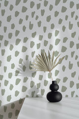 Self-adhesive wallpaper with abstract green spots on a light background, adding a modern and playful accent to the room.