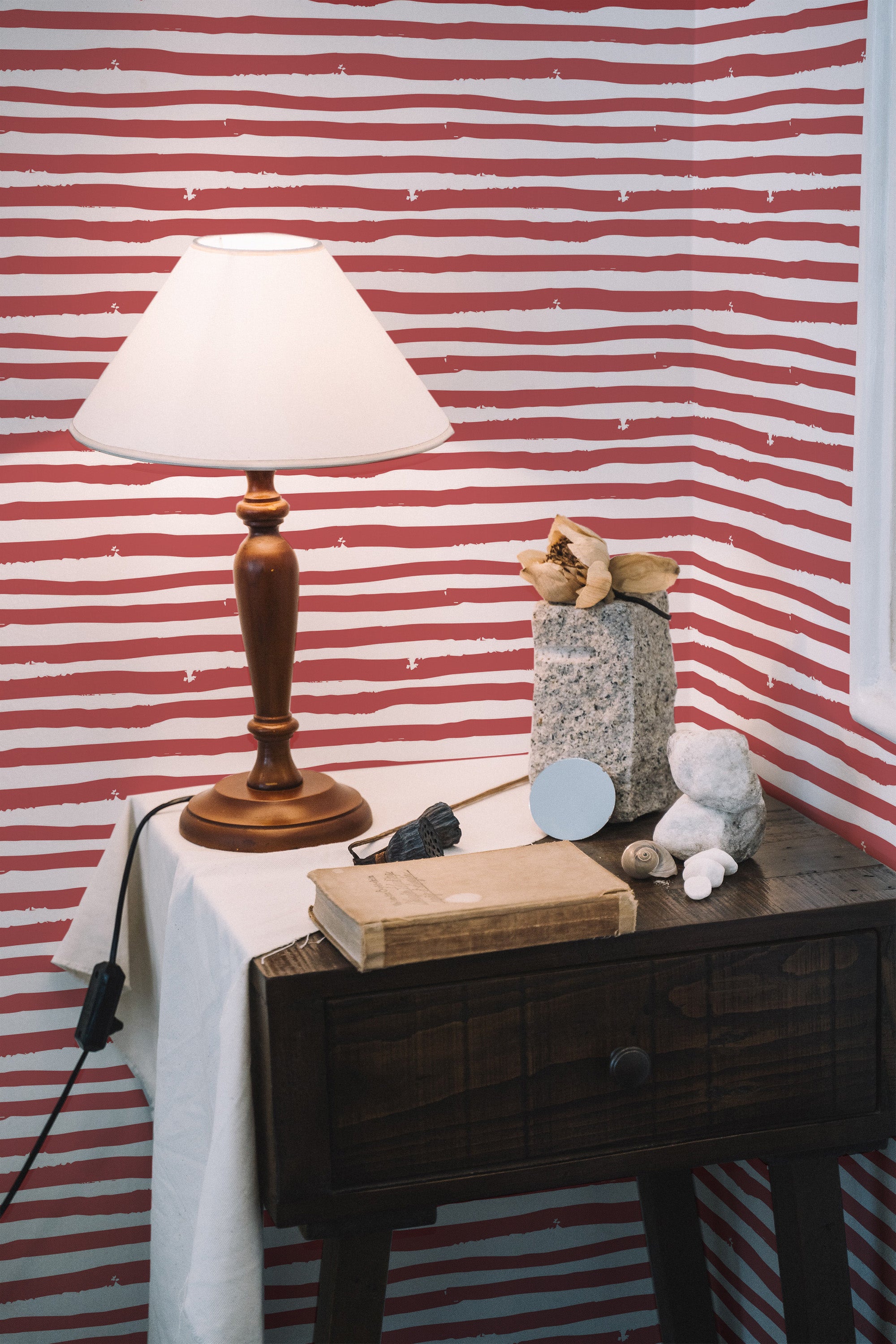 Self-adhesive wallpaper with horizontal red stripes set against a white background, creating a bold and vibrant design. The stripes are uneven, giving a hand-painted appearance, adding a rustic and artistic touch to the room.