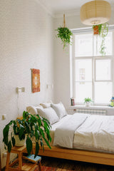 A room with light-colored geometric network wallpaper with intricate, interconnected lines forming a delicate, minimalist pattern, adding subtle texture and depth to the walls. Traditional wallpaper.