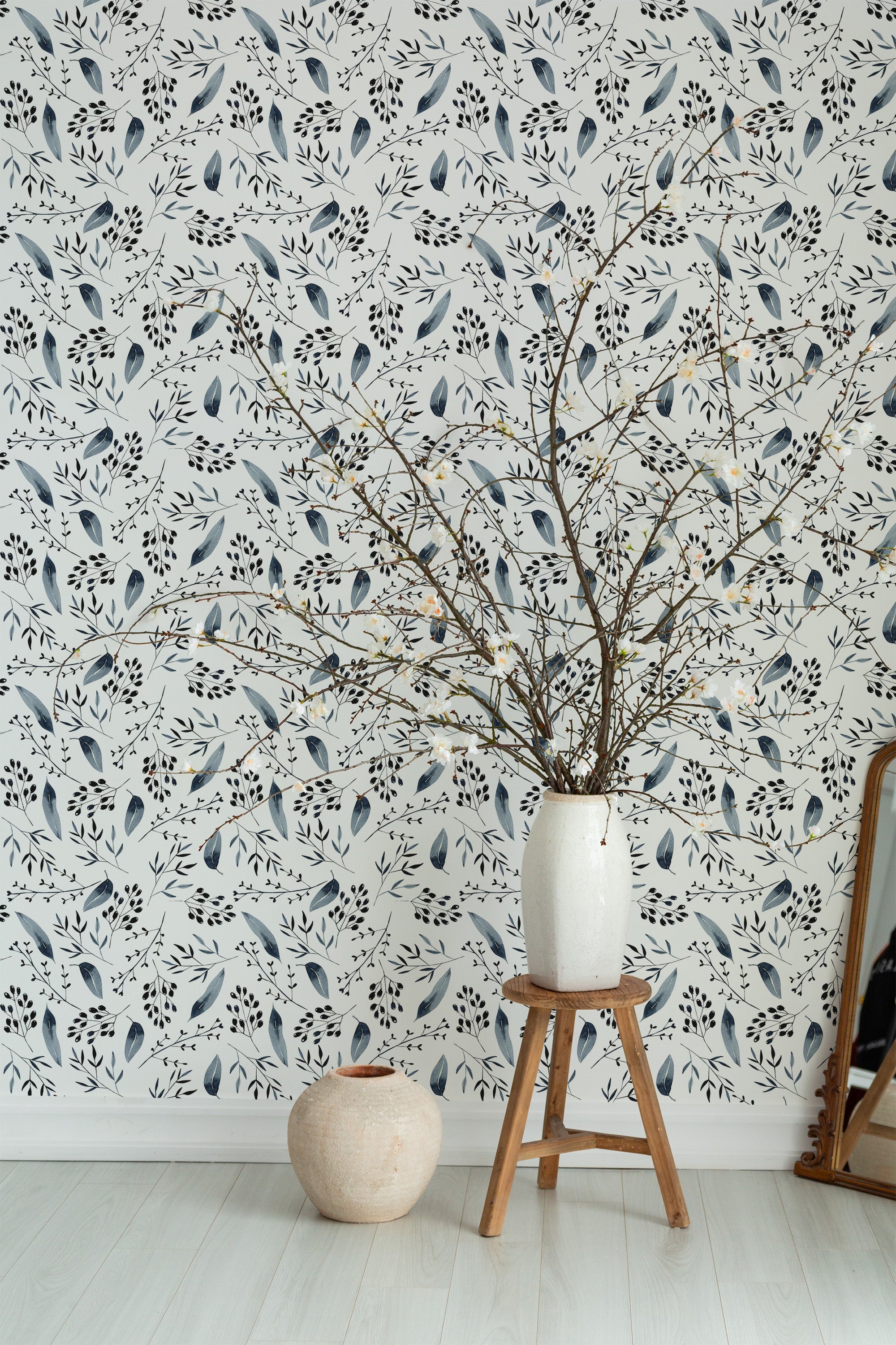Self-adhesive wallpaper in a floral and leaf design, featuring a delicate pattern of blue leaves and black branches against a light background.