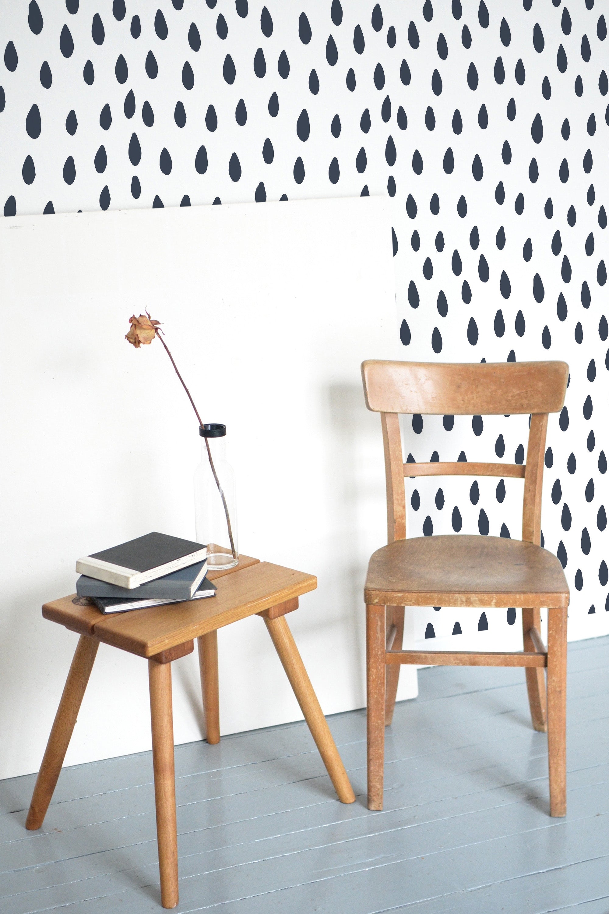 Self-adhesive wallpaper with a seamless rain drops pattern in black on a white background, creating a minimalist and modern look.
