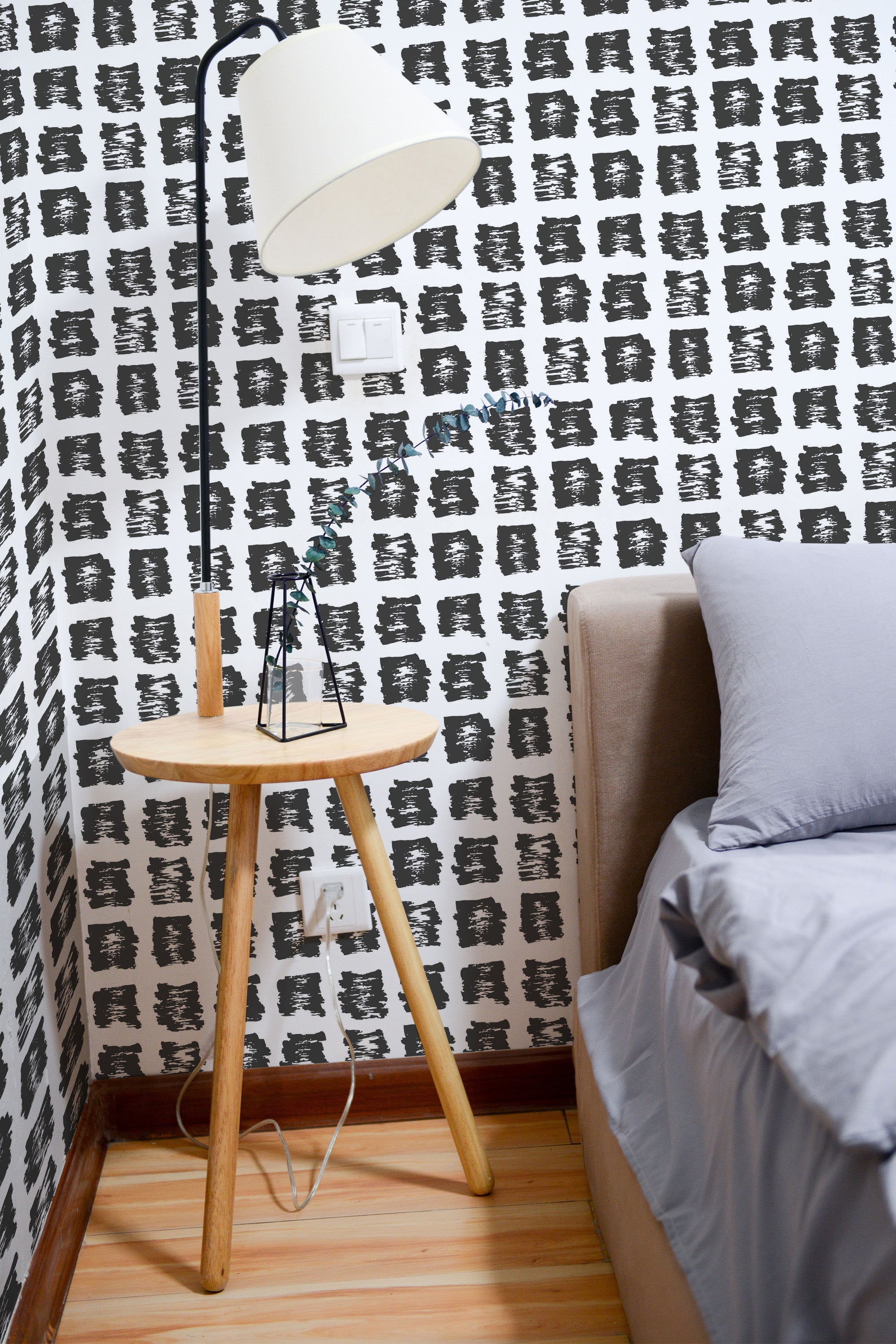 Self-adhesive wallpaper with a black abstract paint spots pattern applied to a white background, adding a bold, artistic touch to the room.
