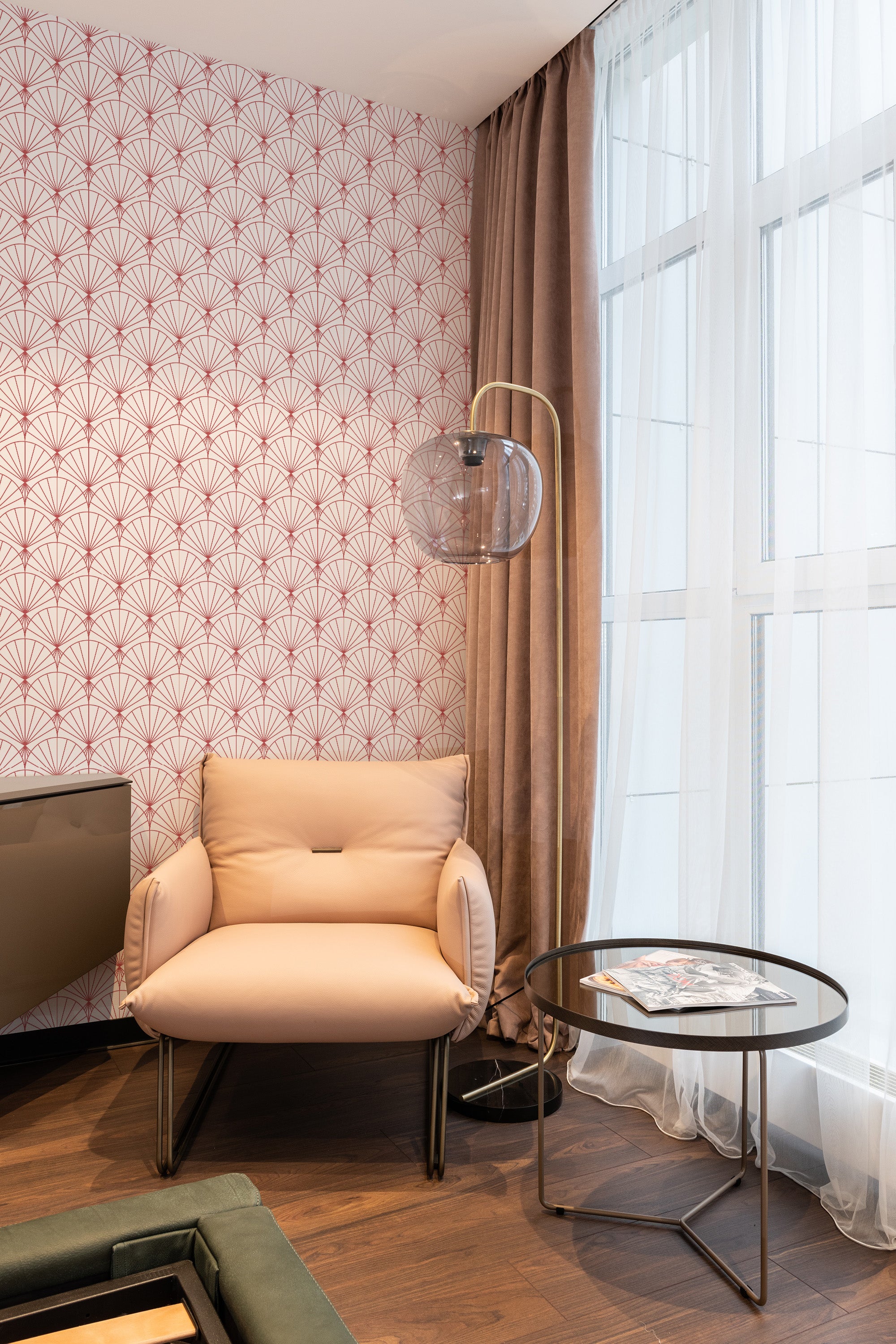 Art Deco-inspired wallpaper with a repeating fan-shaped pattern in soft red on a white background. The design creates a vintage and elegant feel, complementing the modern furniture and neutral tones in the room. Traditional wallpaper.