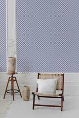 Room with a wall adorned in a blue and white geometric floral wallpaper pattern, combining intricate floral motifs with geometric shapes. Traditional wallpaper.