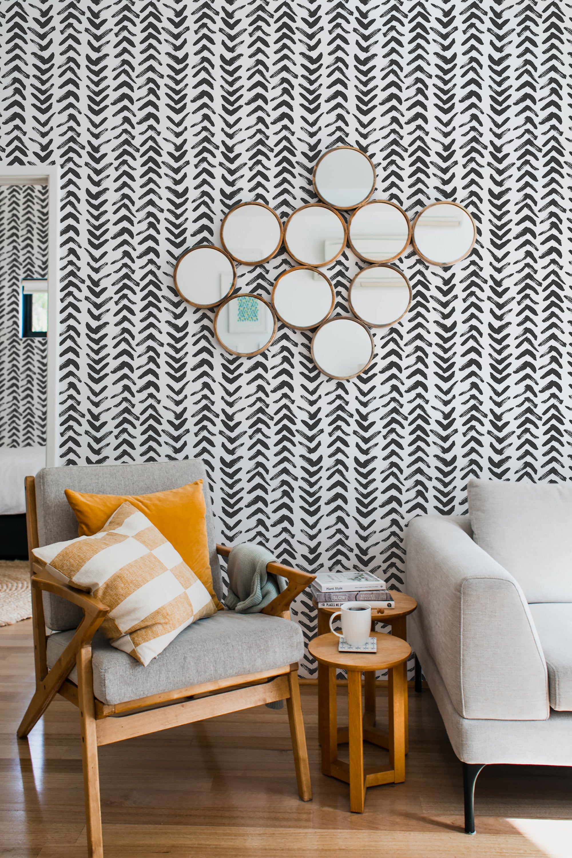 Black brush stroke arrow pattern with a hand-painted look on a white background covers the entire wall, creating a bold, modern, and dynamic visual effect. The look is completed with traditional wallpaper.