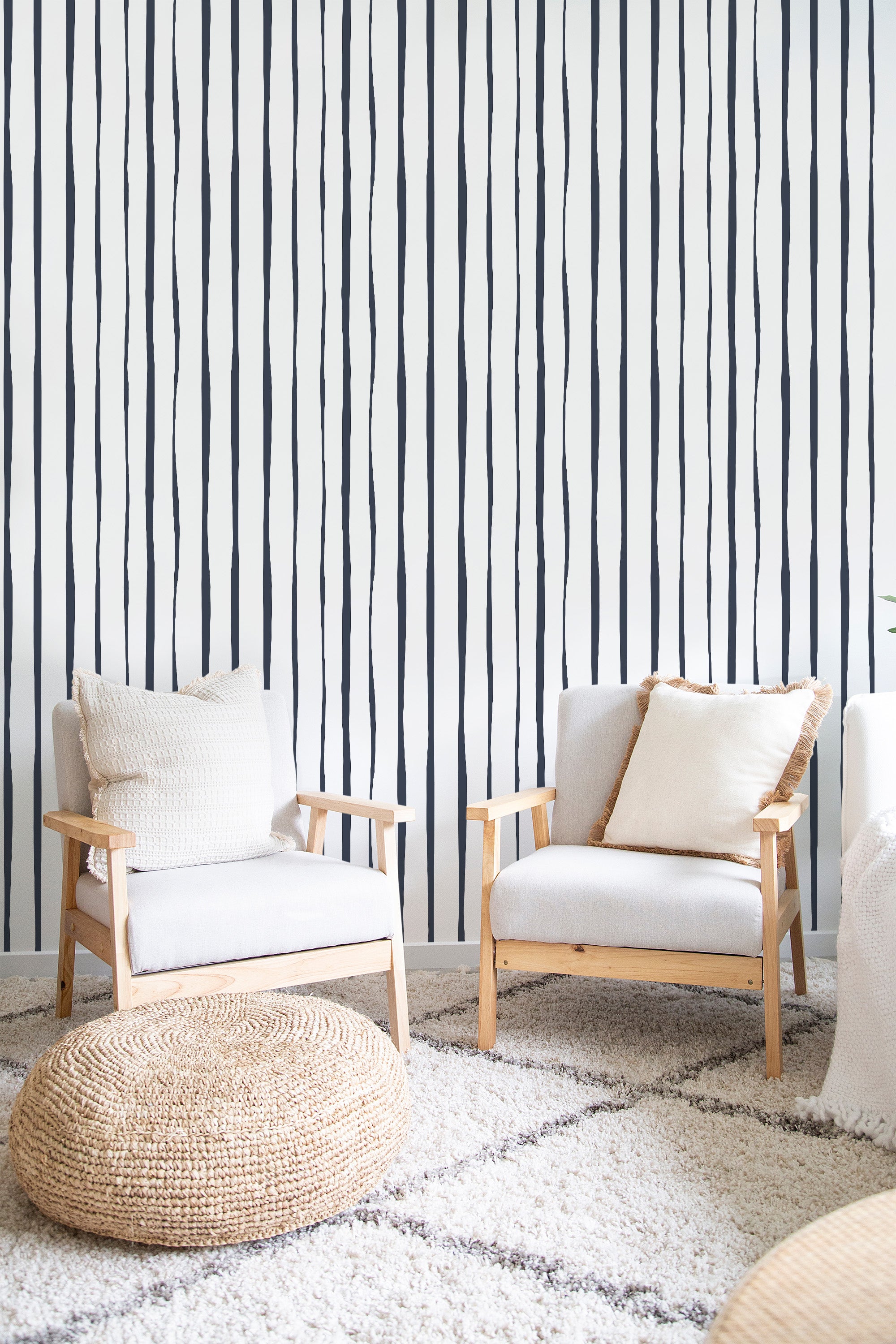 A room with with a vertical line abstract wallpaper pattern. The wallpaper features irregular black vertical lines on a white background, creating a modern yet timeless look in a traditional wallpaper.
