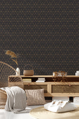 Geometric patterns of intersecting lines in gold, forming intricate star shapes on a dark background create a luxurious, traditional wallpaper.