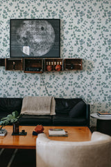 Room with plant-themed wallpaper, decorated with green leaves and vines on a light background, traditional wallpaper.