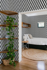 Black and white bold rhombus pattern wallpaper in a geometric design covers the walls, adding a modern yet nostalgic touch to the room. Traditional wallpaper.