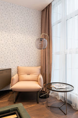 A room with a geometric pattern on the walls arranged in a random, intricate lattice of triangles against a light background, creating a subtle, contemporary mosaic look, complemented by a warm-toned, modern interior. Traditional wallpaper.