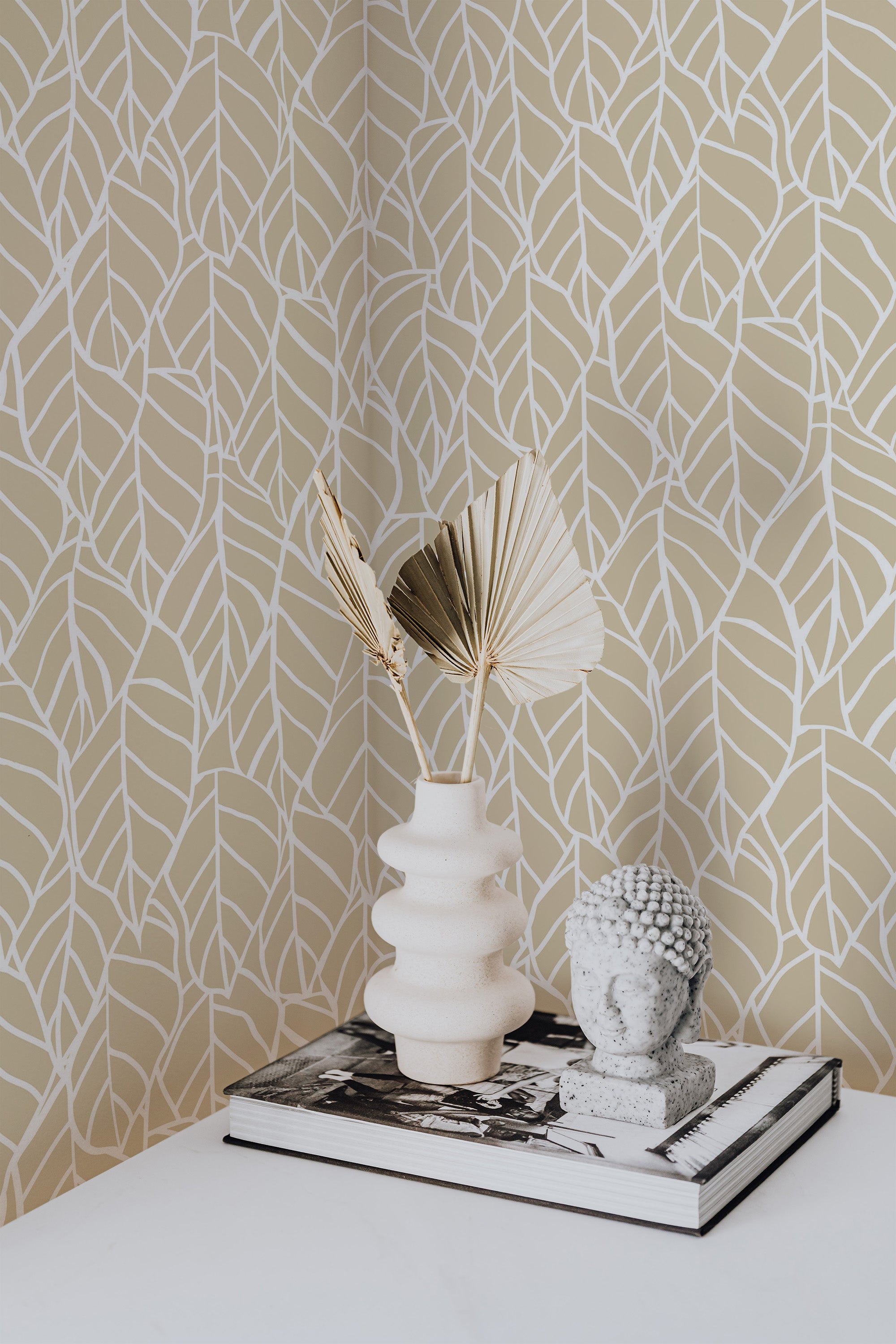 Self-adhesive wallpaper with a hand-drawn leaf design in off-white on a beige background, bringing a natural and minimalist vibe to the room.